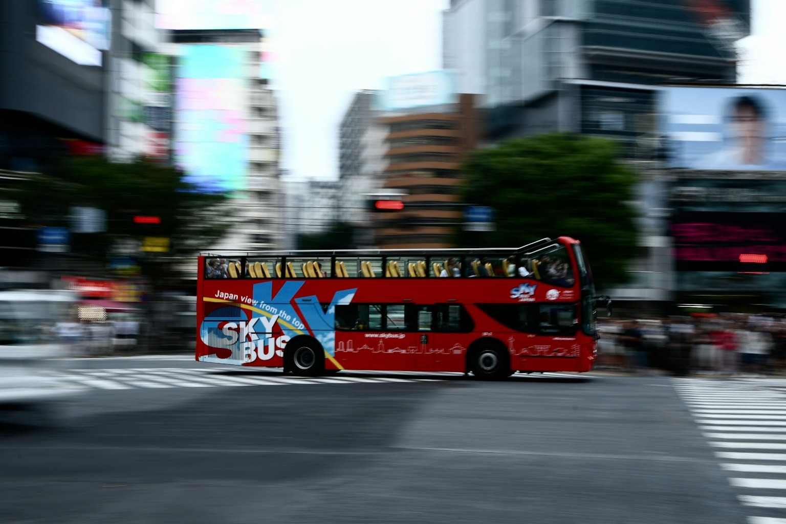 红色观光巴士穿过繁忙的城市区域