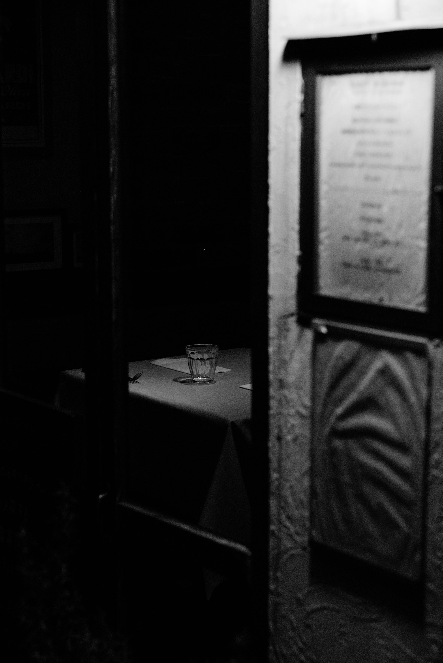 Dimly lit restaurant entrance featuring a menu and a table