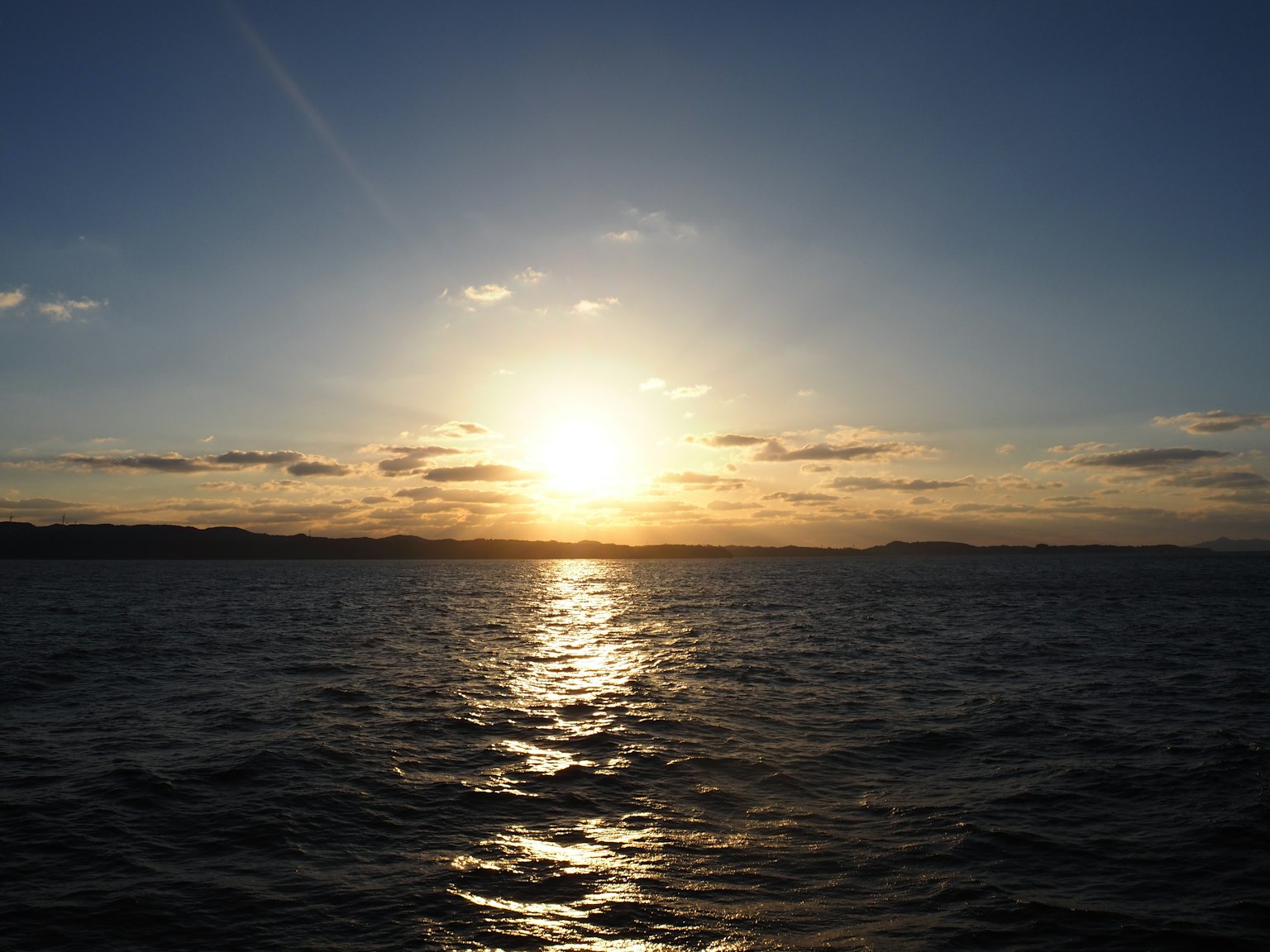 Un tramonto sull'oceano che si riflette sull'acqua