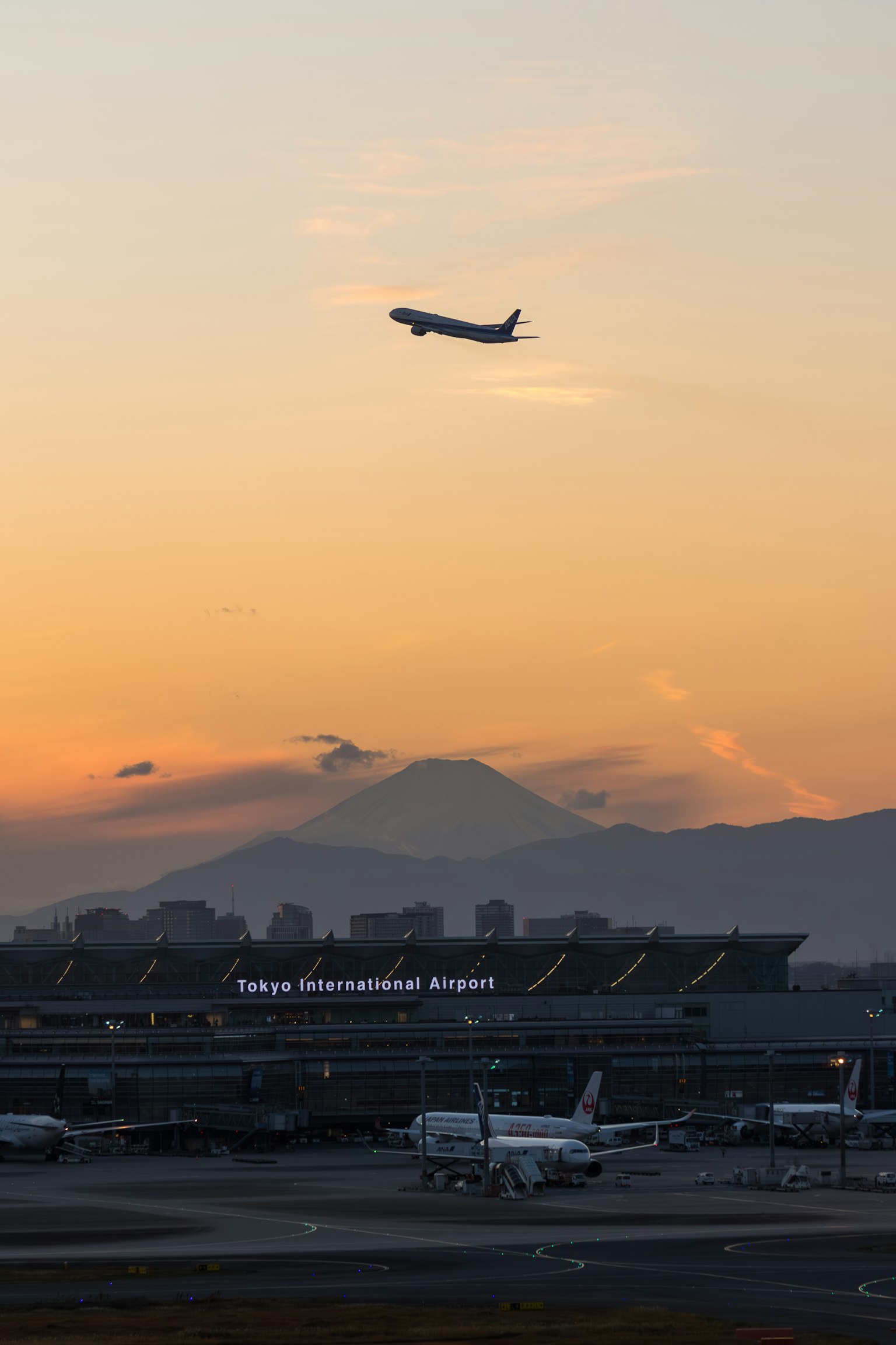 Avion décollant contre un ciel au coucher du soleil à l'aéroport international de Haneda