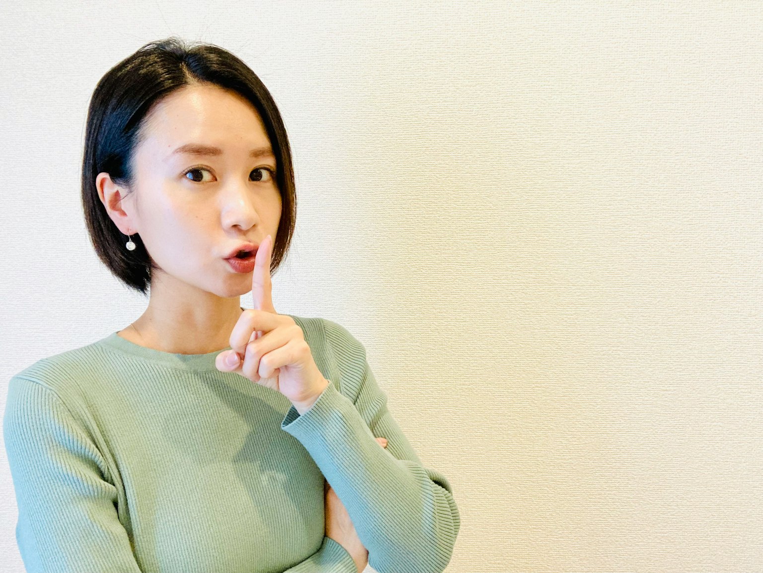 여성이 입술에 손가락을 대고 조용히 하라고 제스처를 취하고 있다