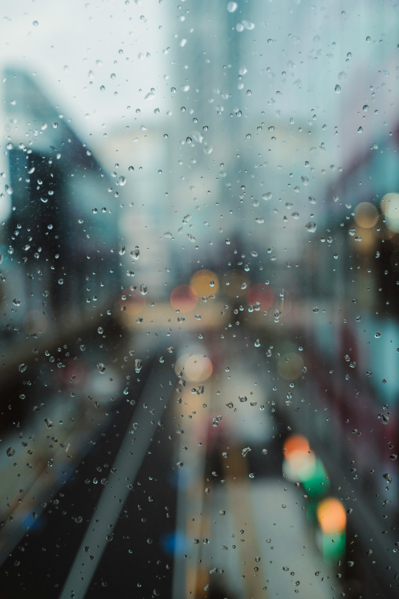 雨粒の付いた窓越しに伸びる街の通り