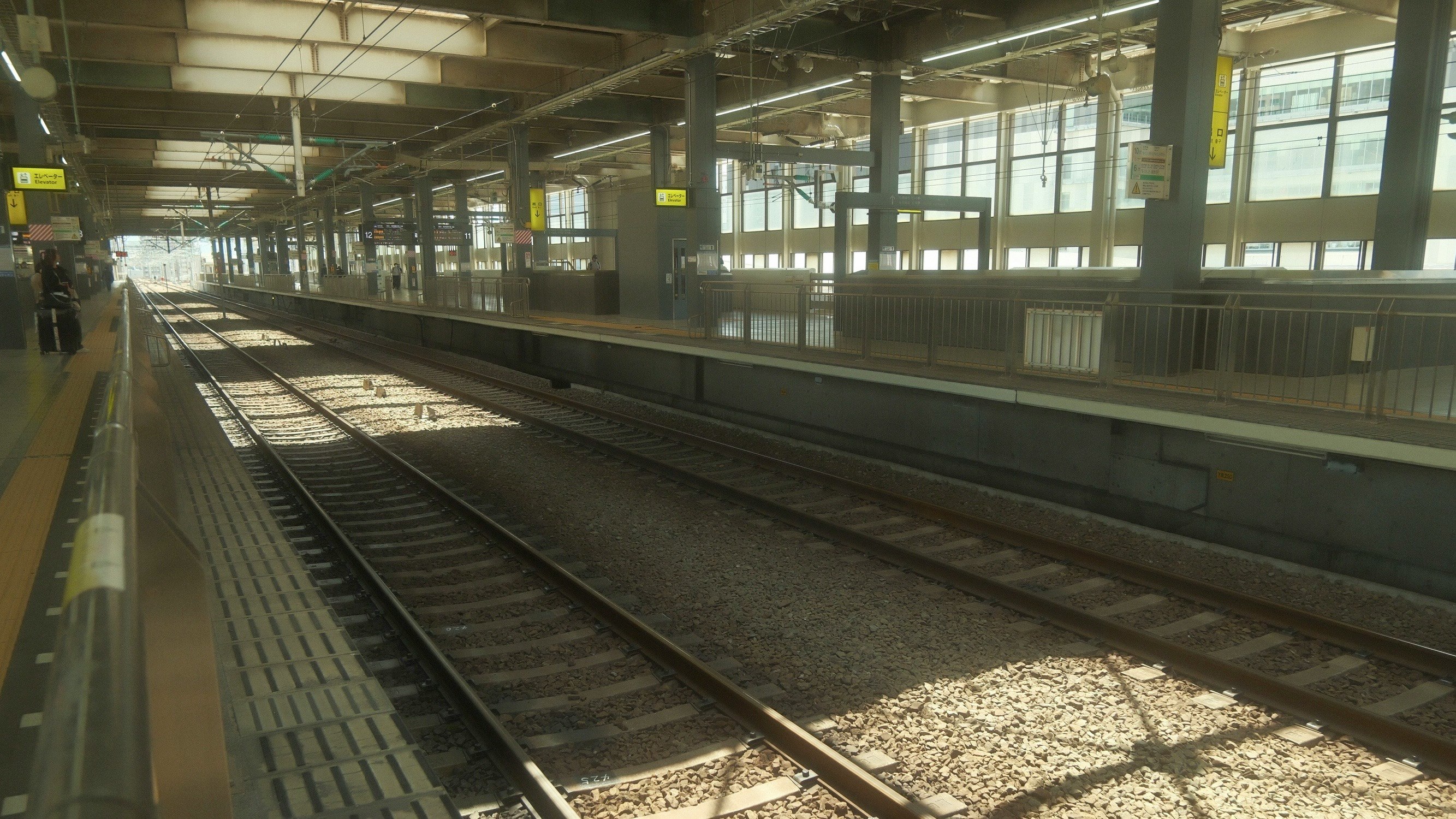 駅のホームに並ぶ線路とホームのベンチ