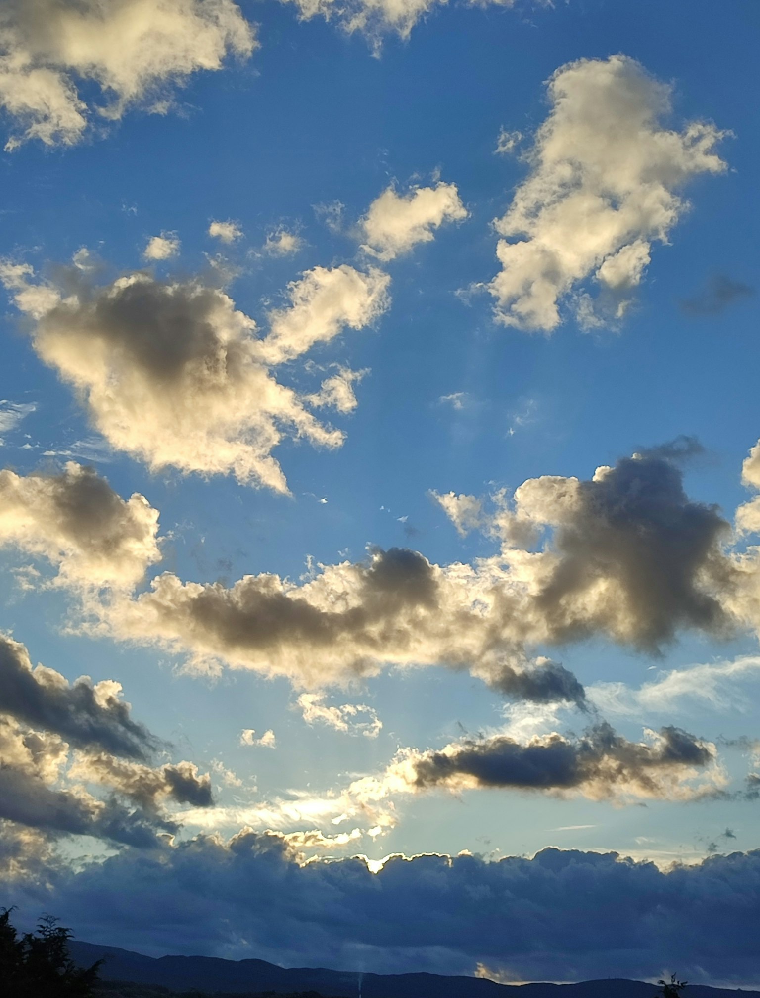 Nuvole soffici in un cielo blu illuminate dal tramonto