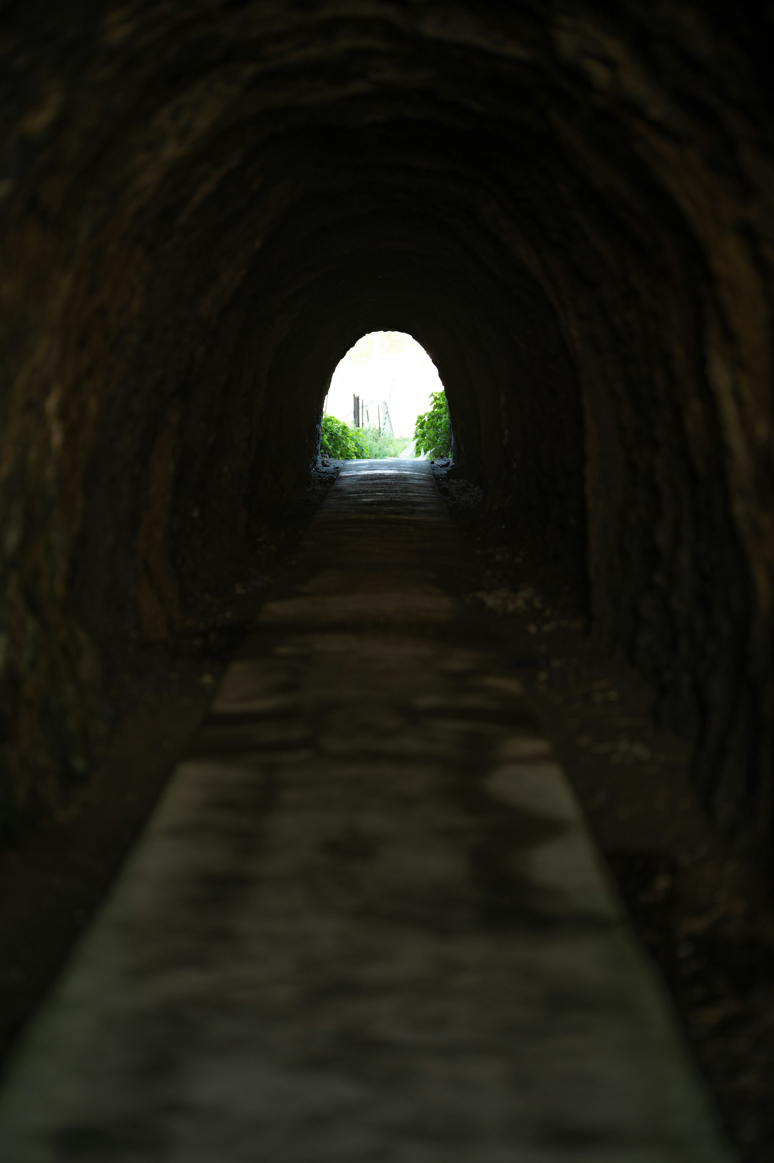 View of a lighted entrance from inside a tunnel