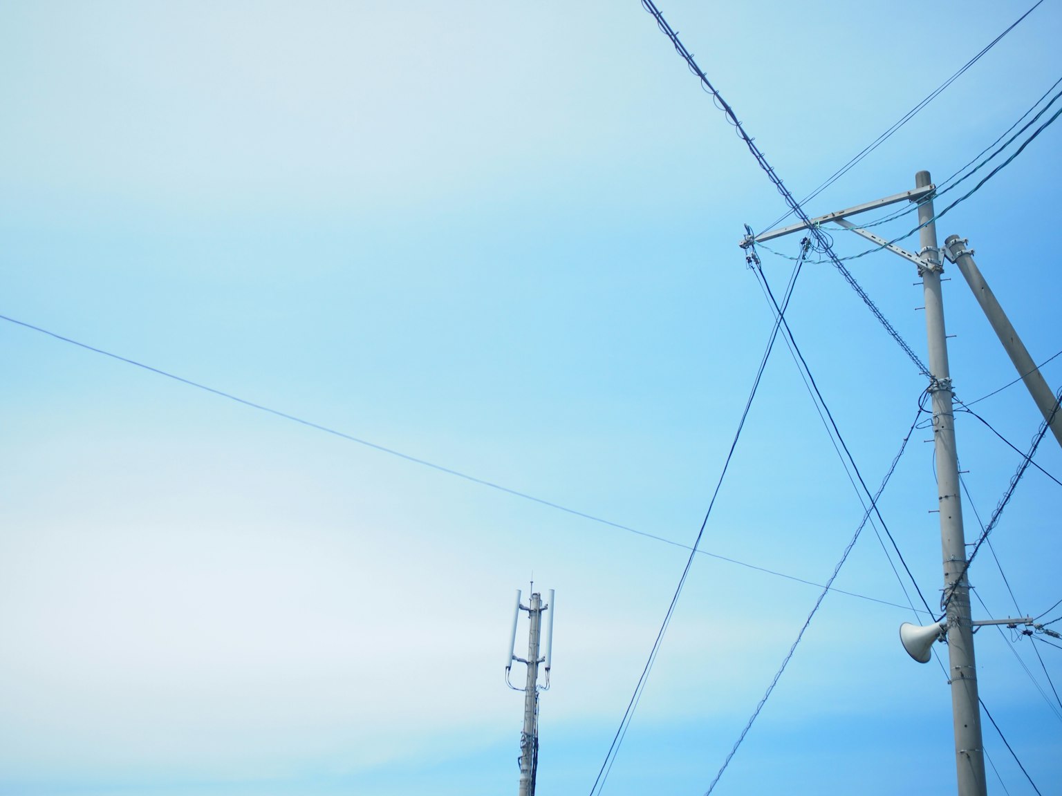 Simple landscape with blue sky and intersecting utility poles