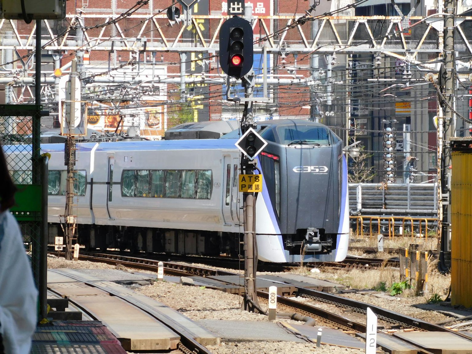 新幹線が駅に接近するシーン 鉄道信号と周囲の架線が見える