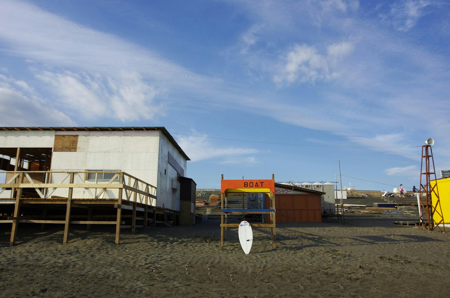 Beach scene featuring wooden structures and a bright blue sky