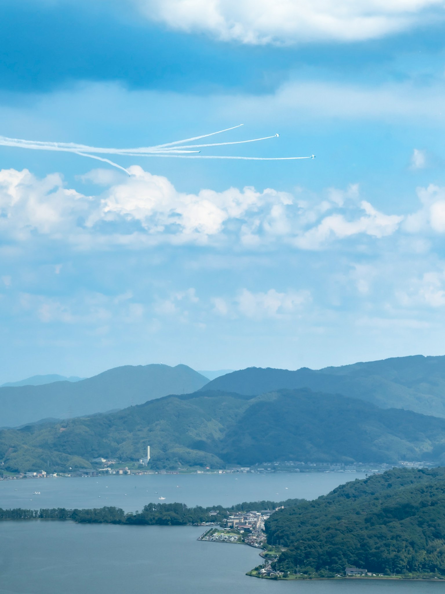 Vue pittoresque avec des traînées d'avion dans un ciel bleu et des montagnes en arrière-plan