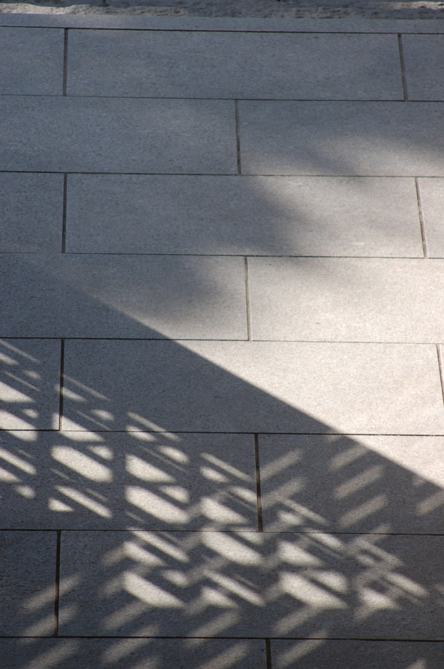 Motifs d'ombre sur une surface carrelée grise