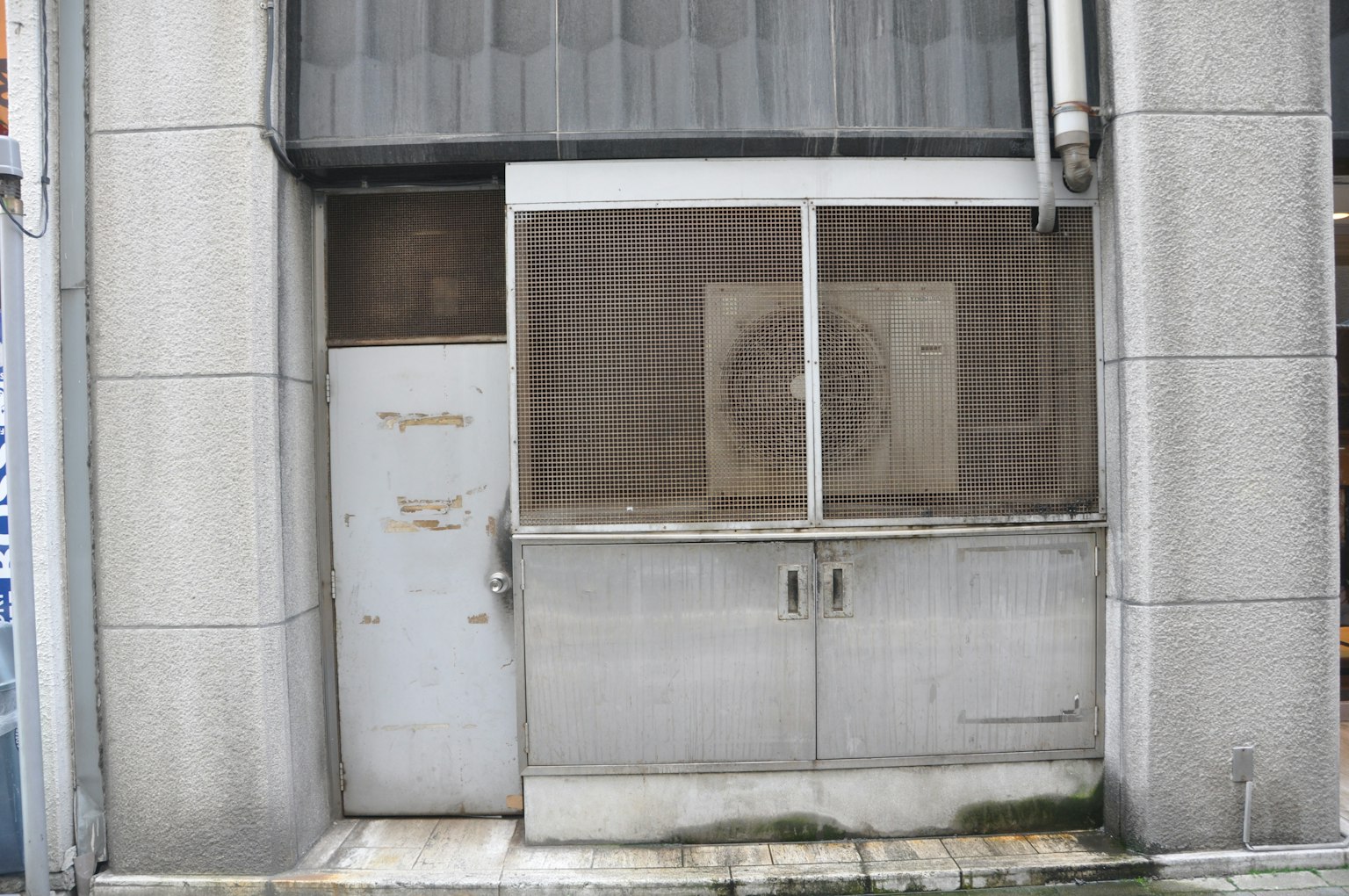 Esterno di un edificio con una vecchia porta in metallo e una finestra