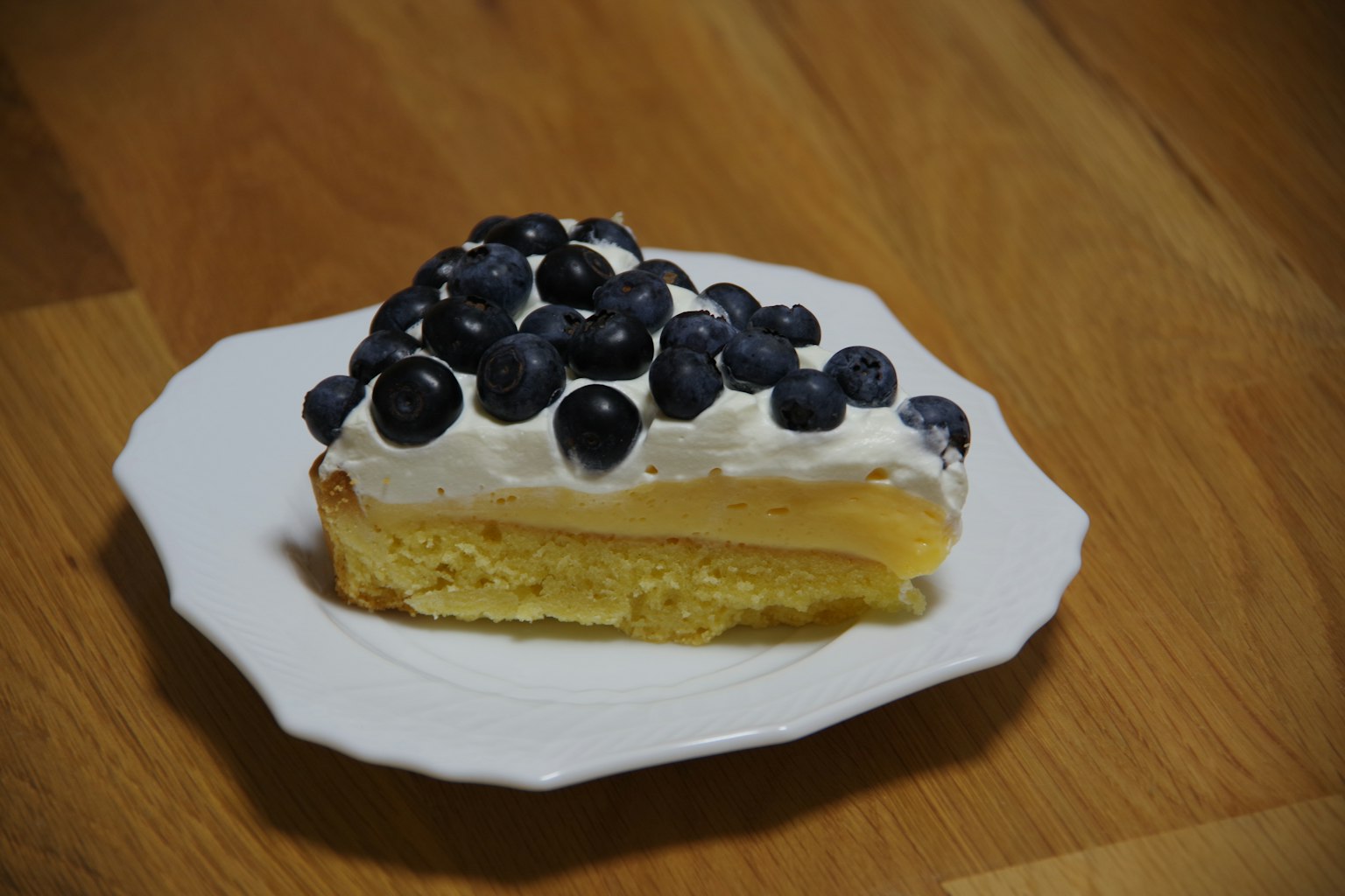 Tranche de gâteau à la crème surmontée de myrtilles