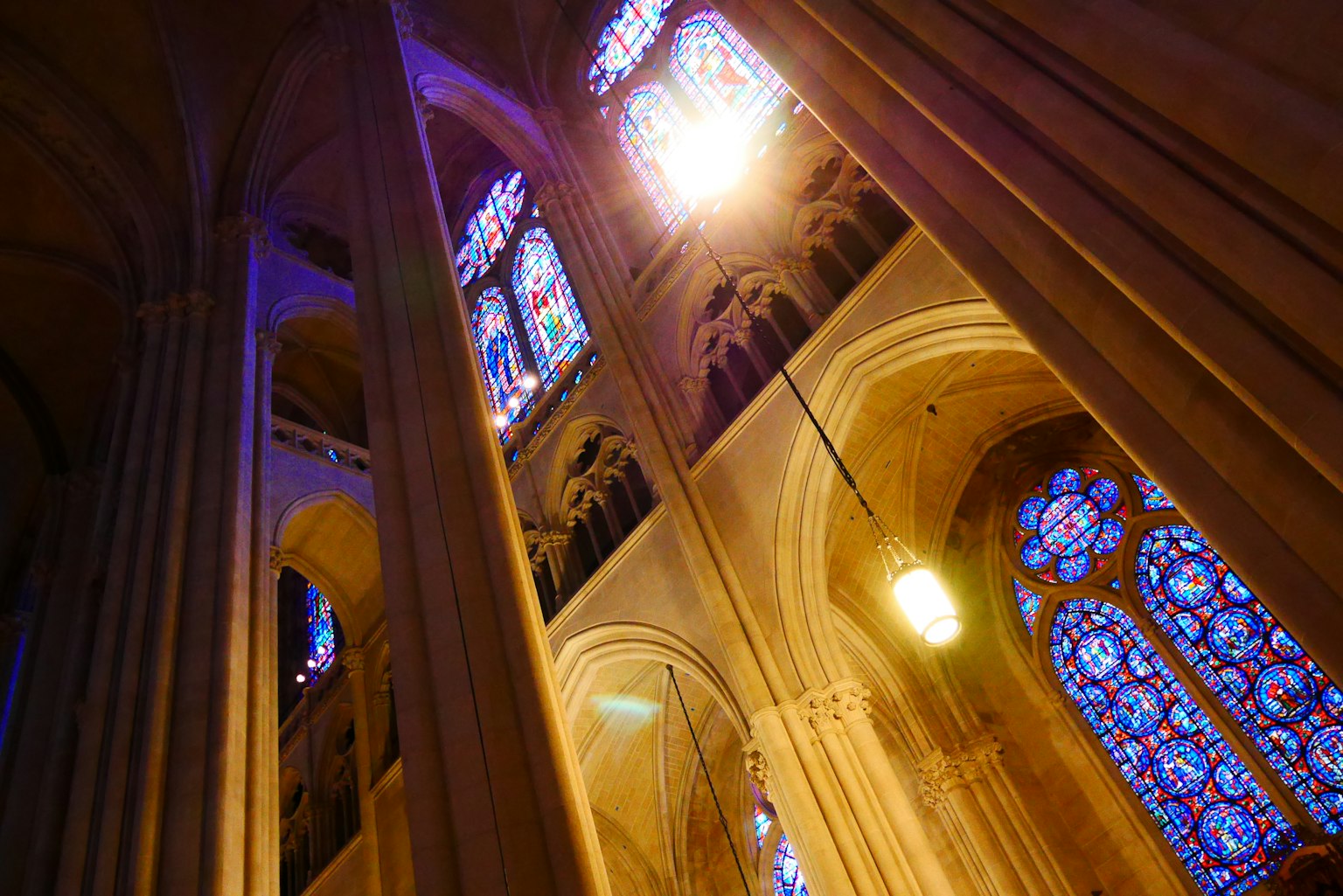 Interior de una iglesia que muestra hermosos vitrales y altos techos