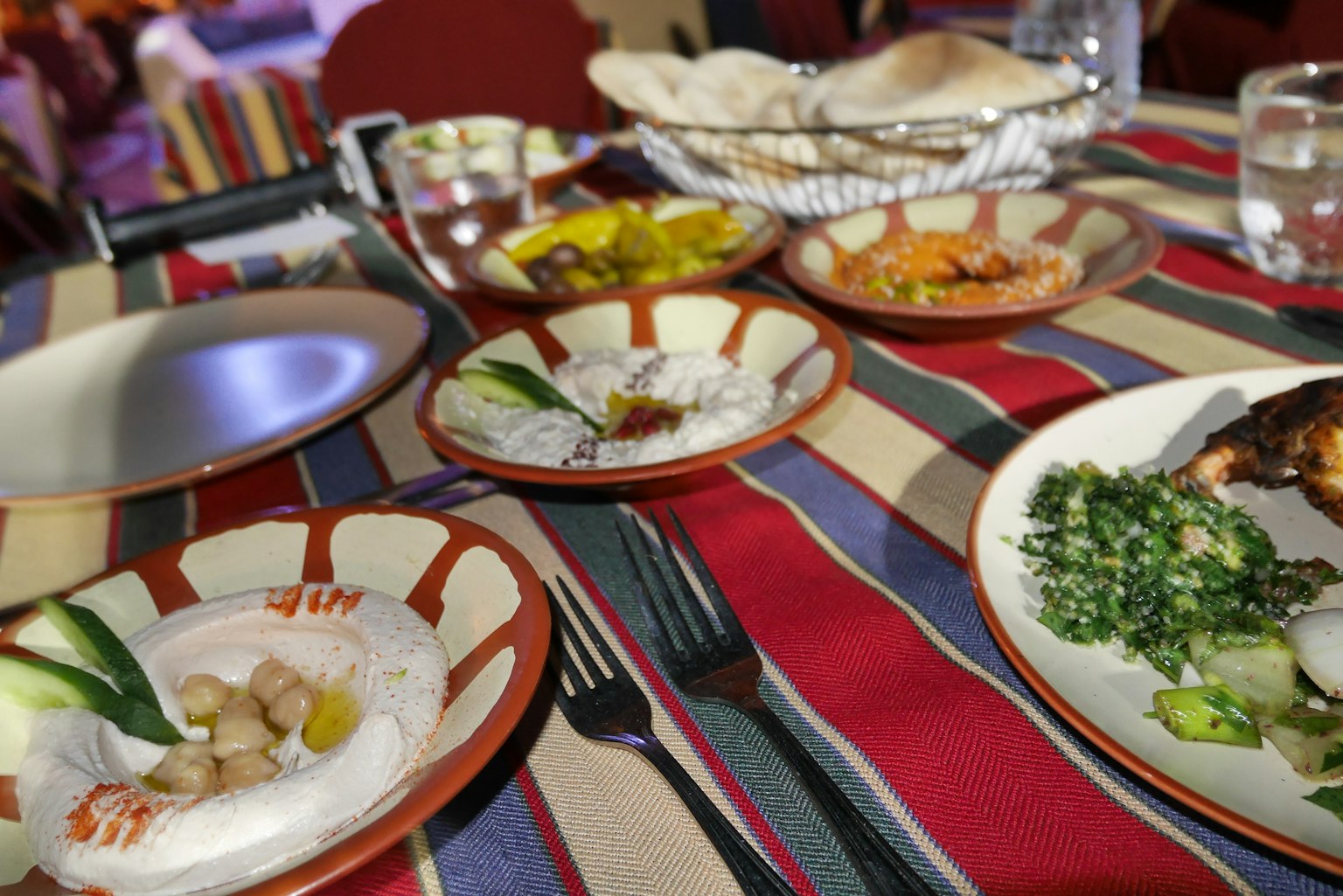 Un tavolo imbandito con piatti colorati che presentano riso e verdure su piatti decorati