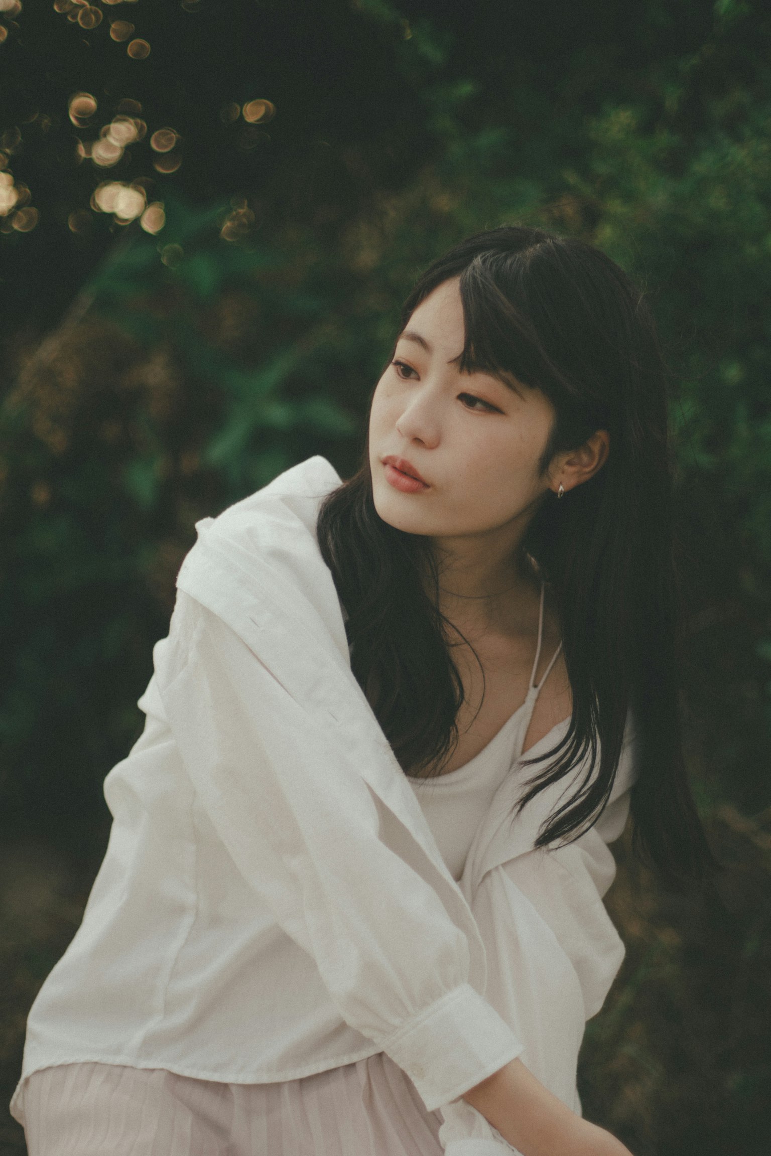 一名穿著白襯衫的女性在大自然中沉思