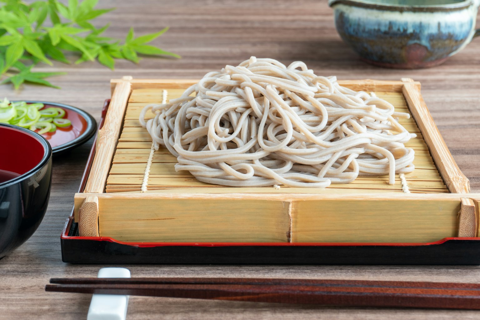 Mie soba disajikan di atas tikar bambu dengan saus celup