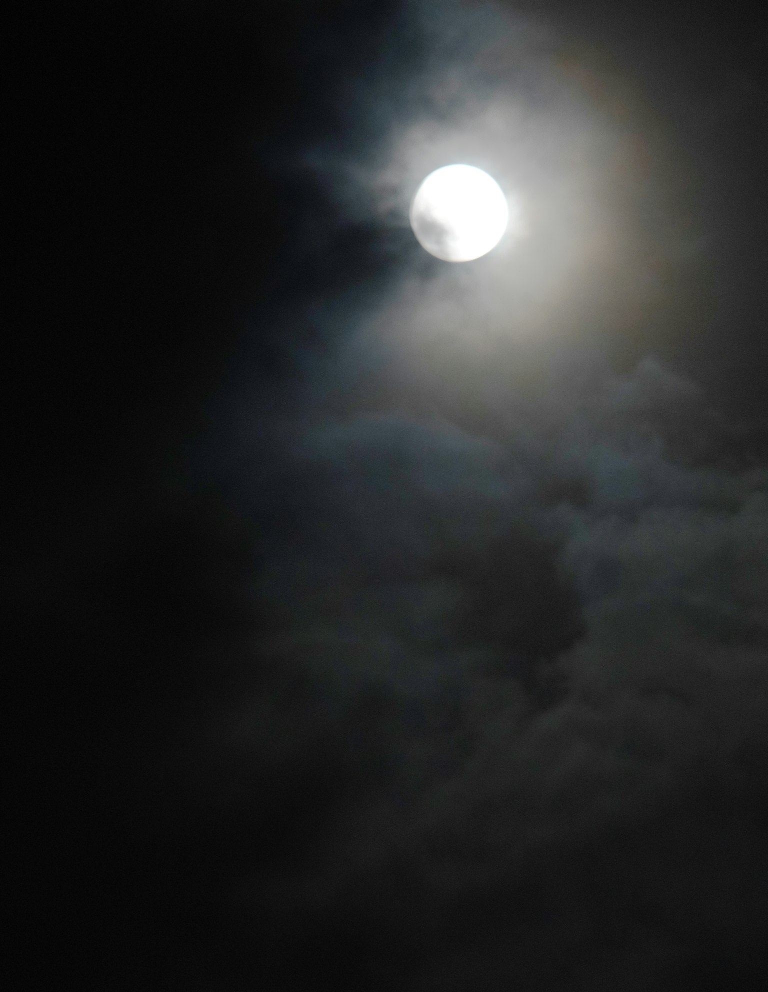 Bulan purnama cerah di langit gelap dengan awan tipis