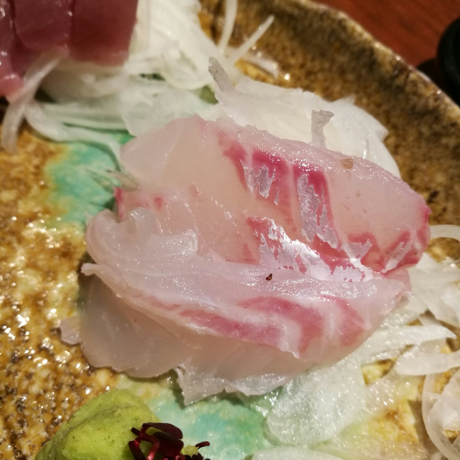 Irisan sashimi segar dengan ikan putih dan garis merah
