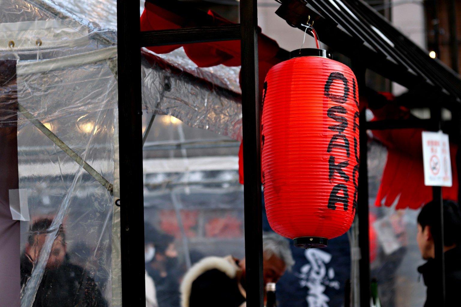 Red lantern displaying 'OSAKA' at a food stall