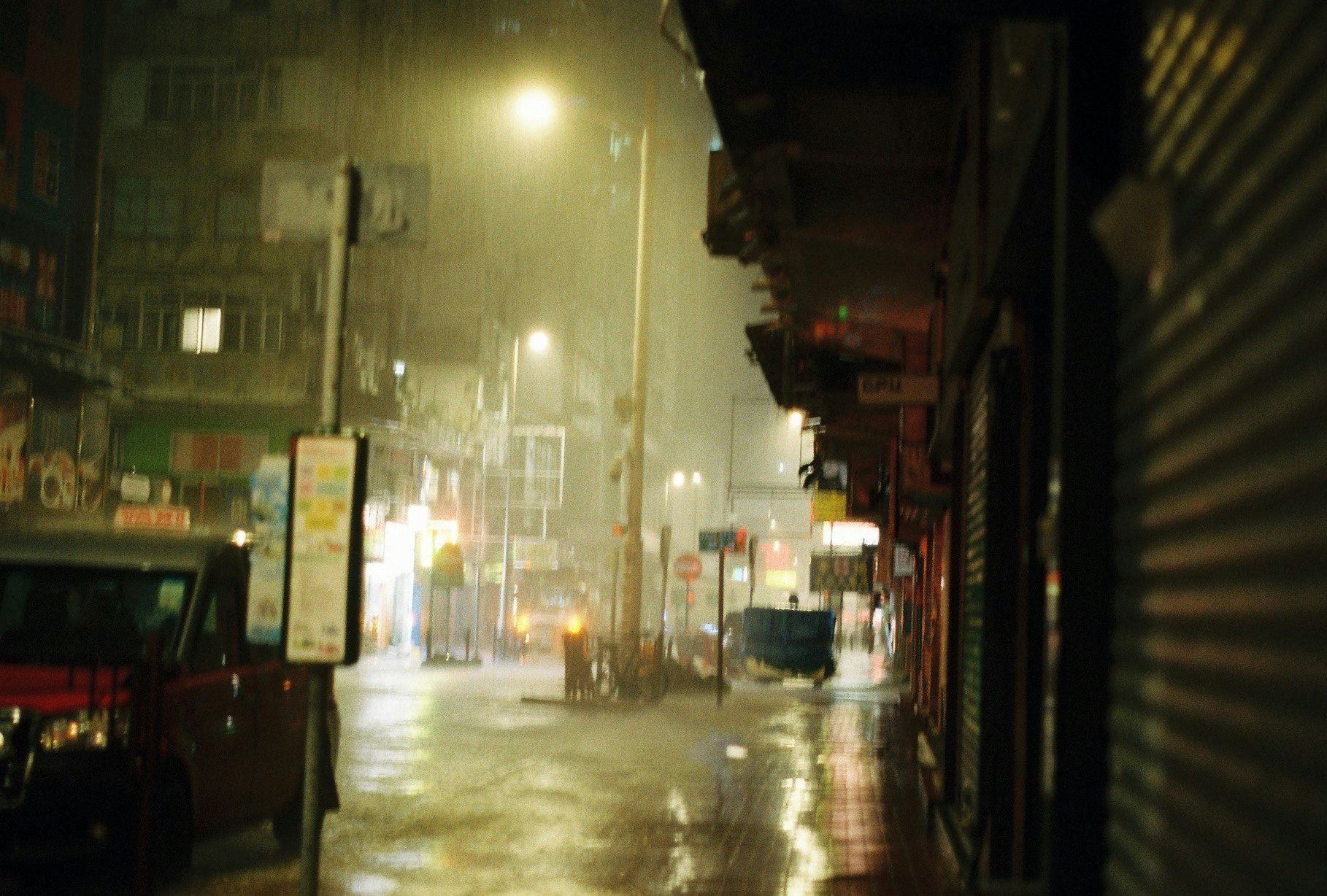 雨上がりの路地で街灯がにじむ夜の商店街