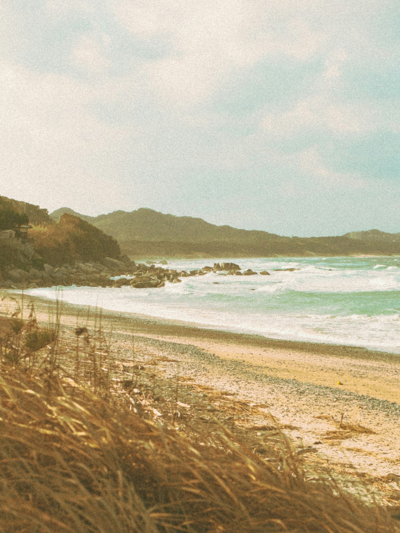 ทิวทัศน์ชายหาดที่เงียบสงบชายหาดทรายและคลื่นในพื้นหลัง