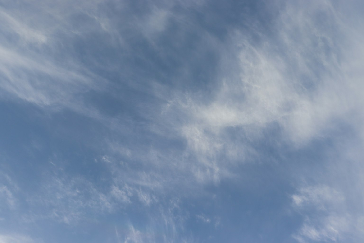 Un cielo azul claro con nubes blancas dispersas