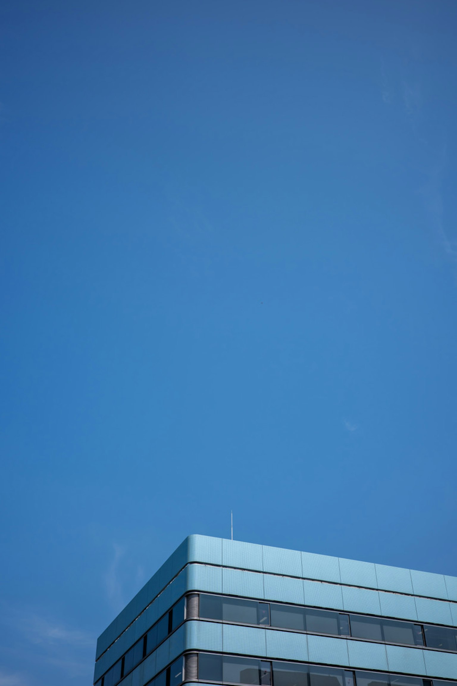 Parte superior de un edificio moderno contra un cielo azul claro
