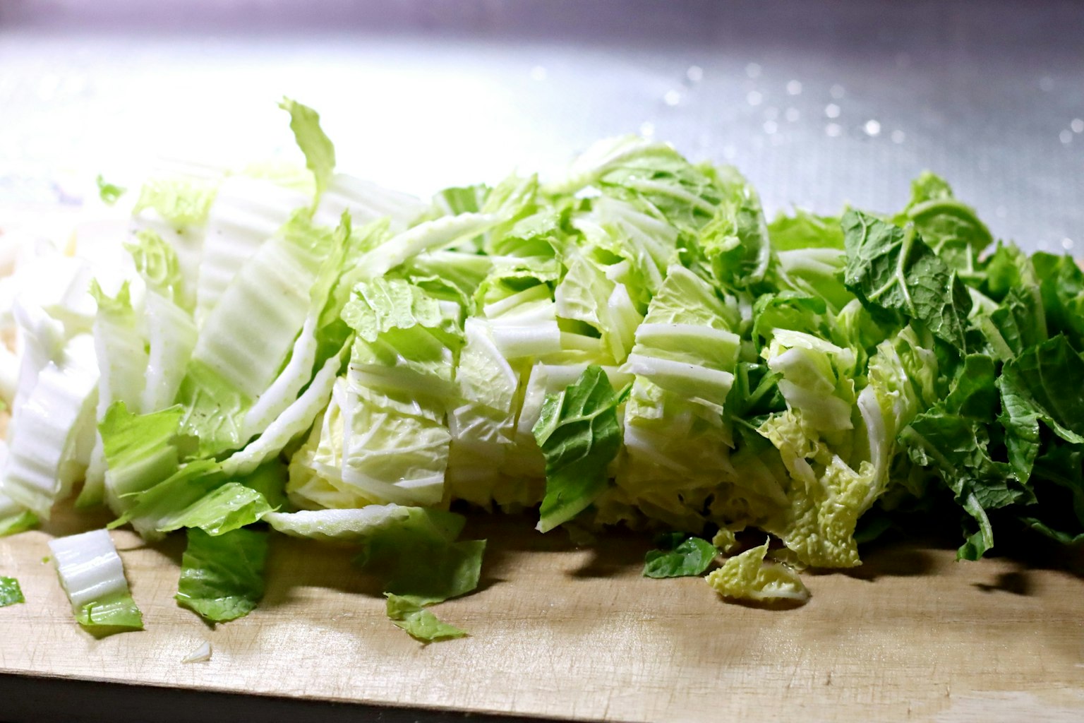 Chopped napa cabbage arranged on a wooden cutting board
