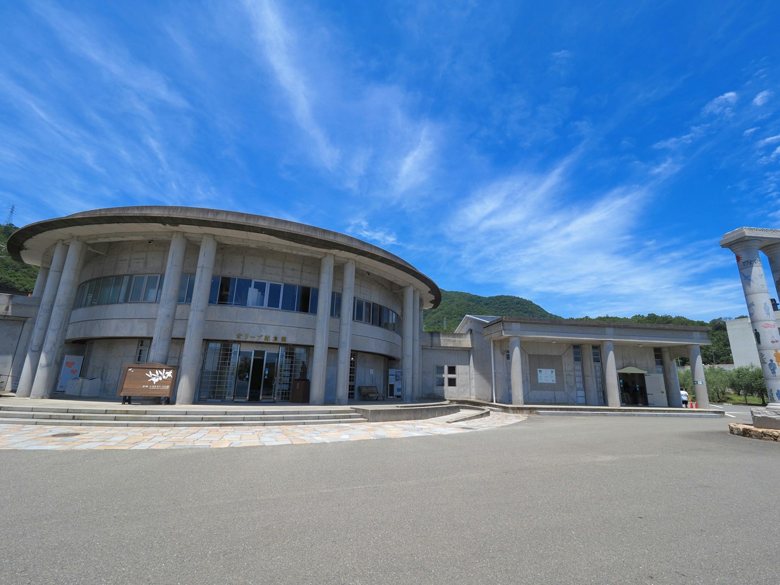 Esterno di un edificio moderno sotto un cielo blu con un tetto circolare