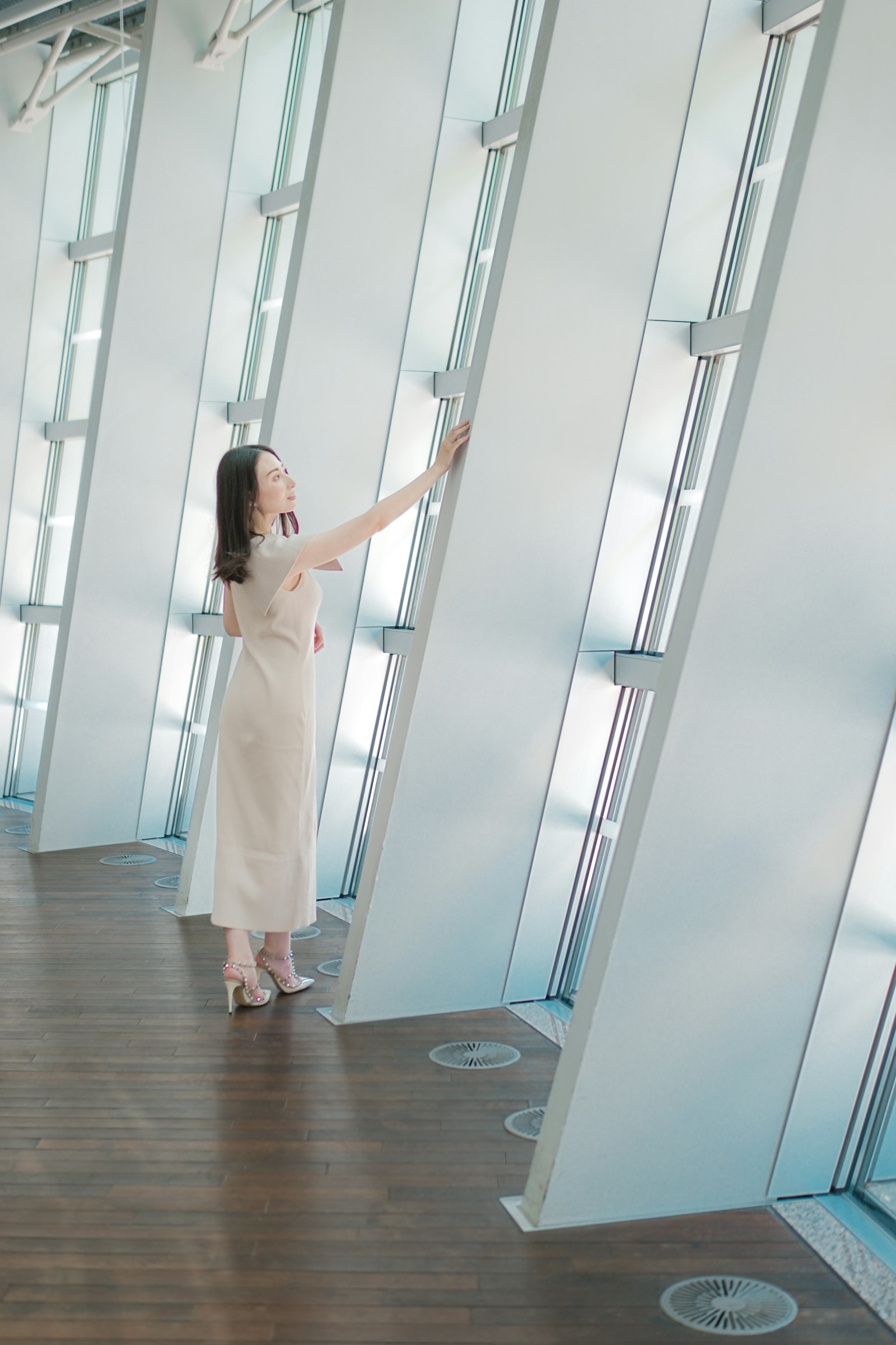 一名女性在现代室内触摸透明墙