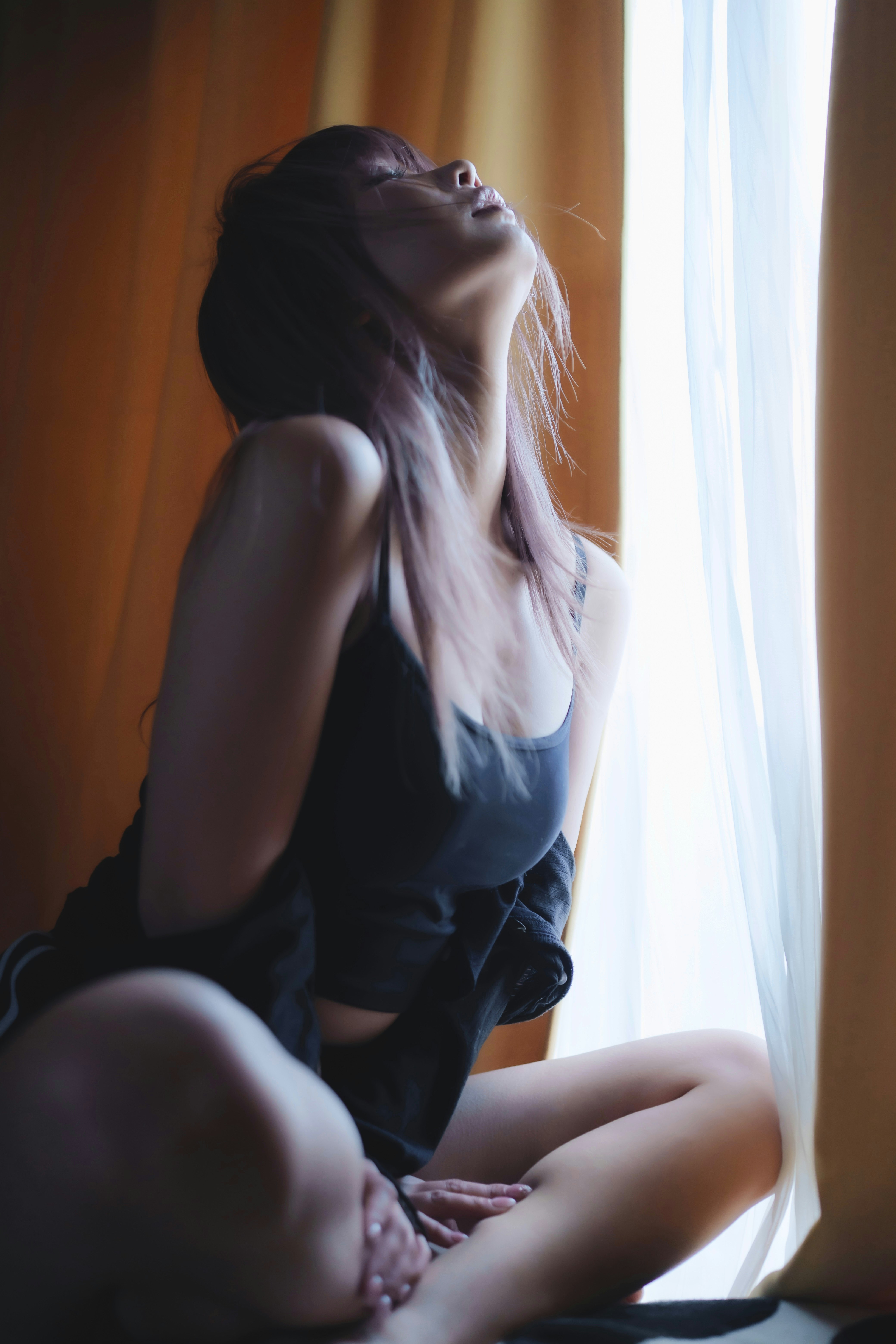 窓辺で見上げる女性のポートレート