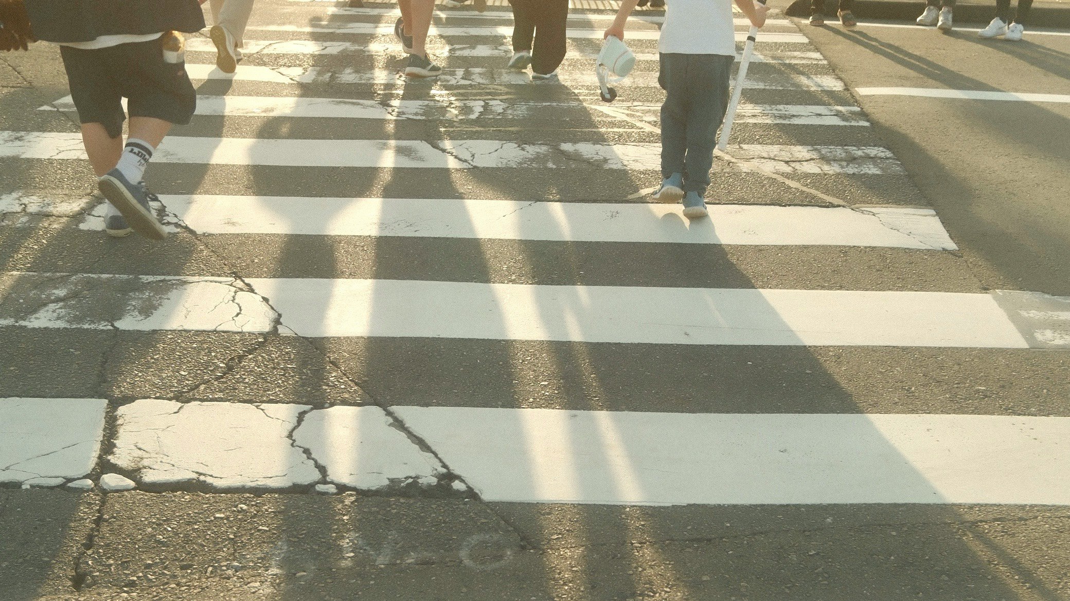 feet of people walking on a crosswalk