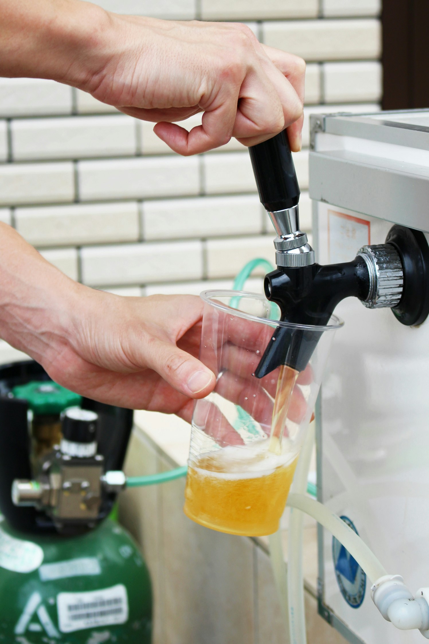 戶外水龍頭旁雙手倒飲料
