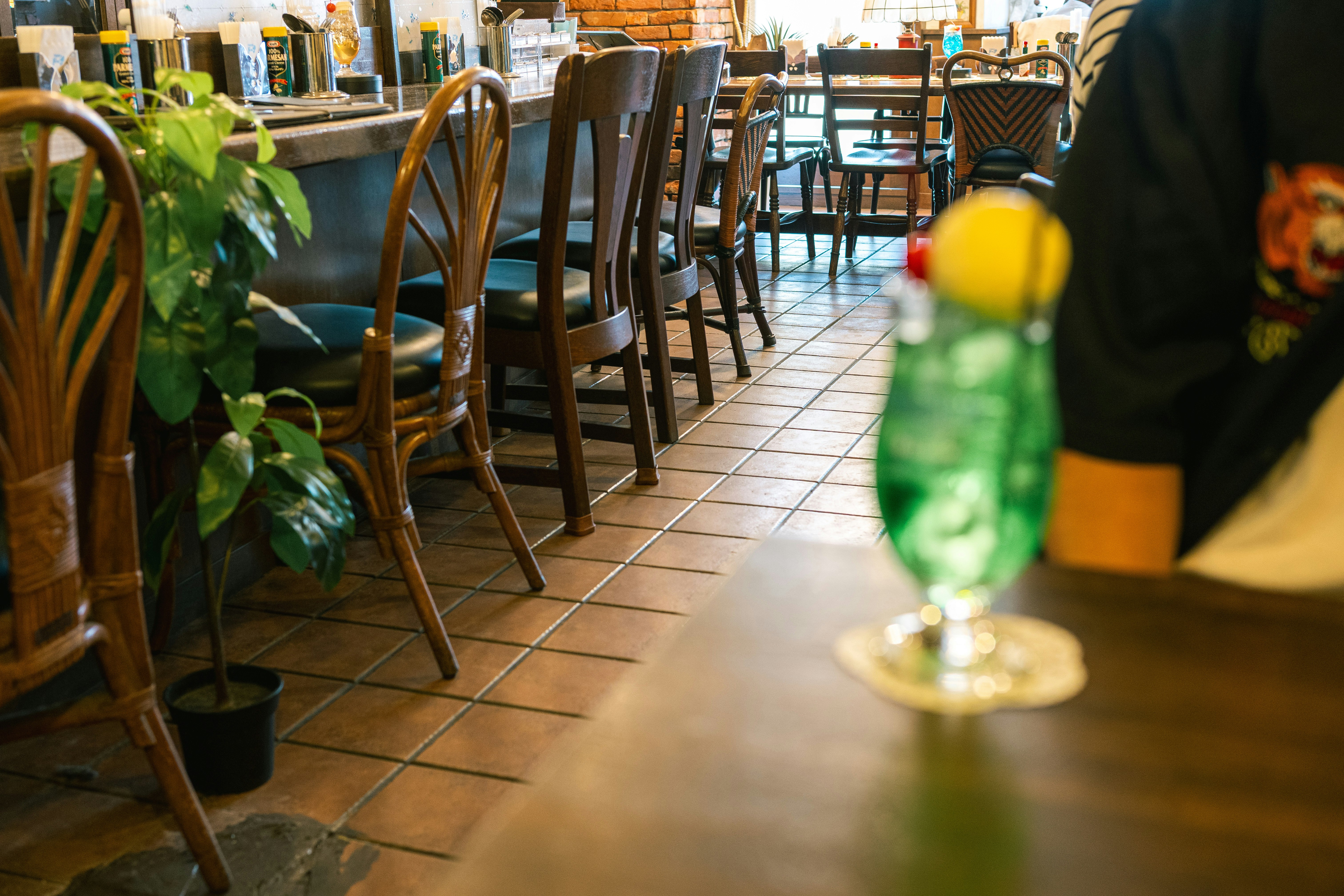 観葉植物のあるカフェ店内のテーブルと椅子の並び