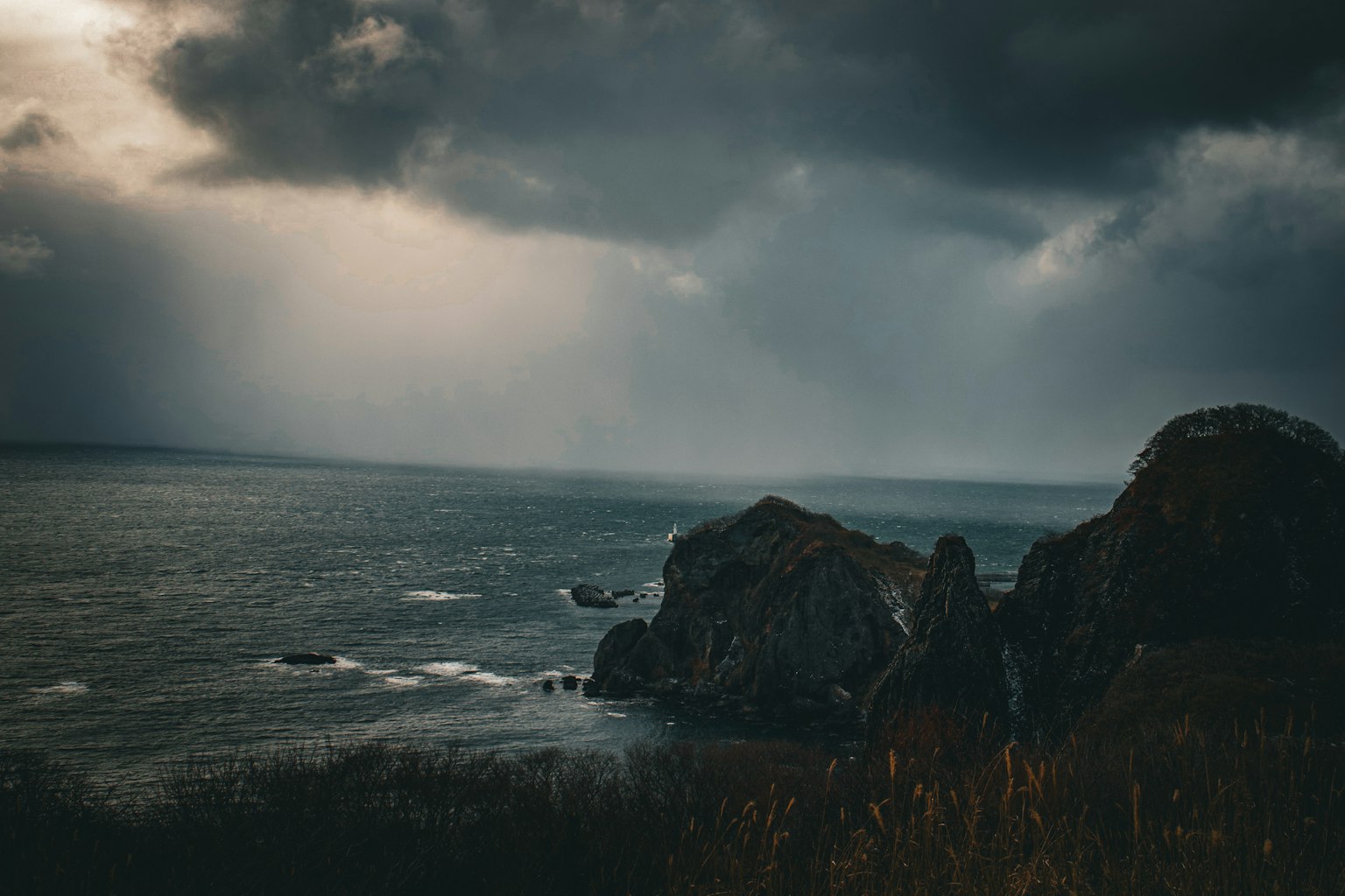 在陰雲下的戲劇性海景與崎嶇的岩石