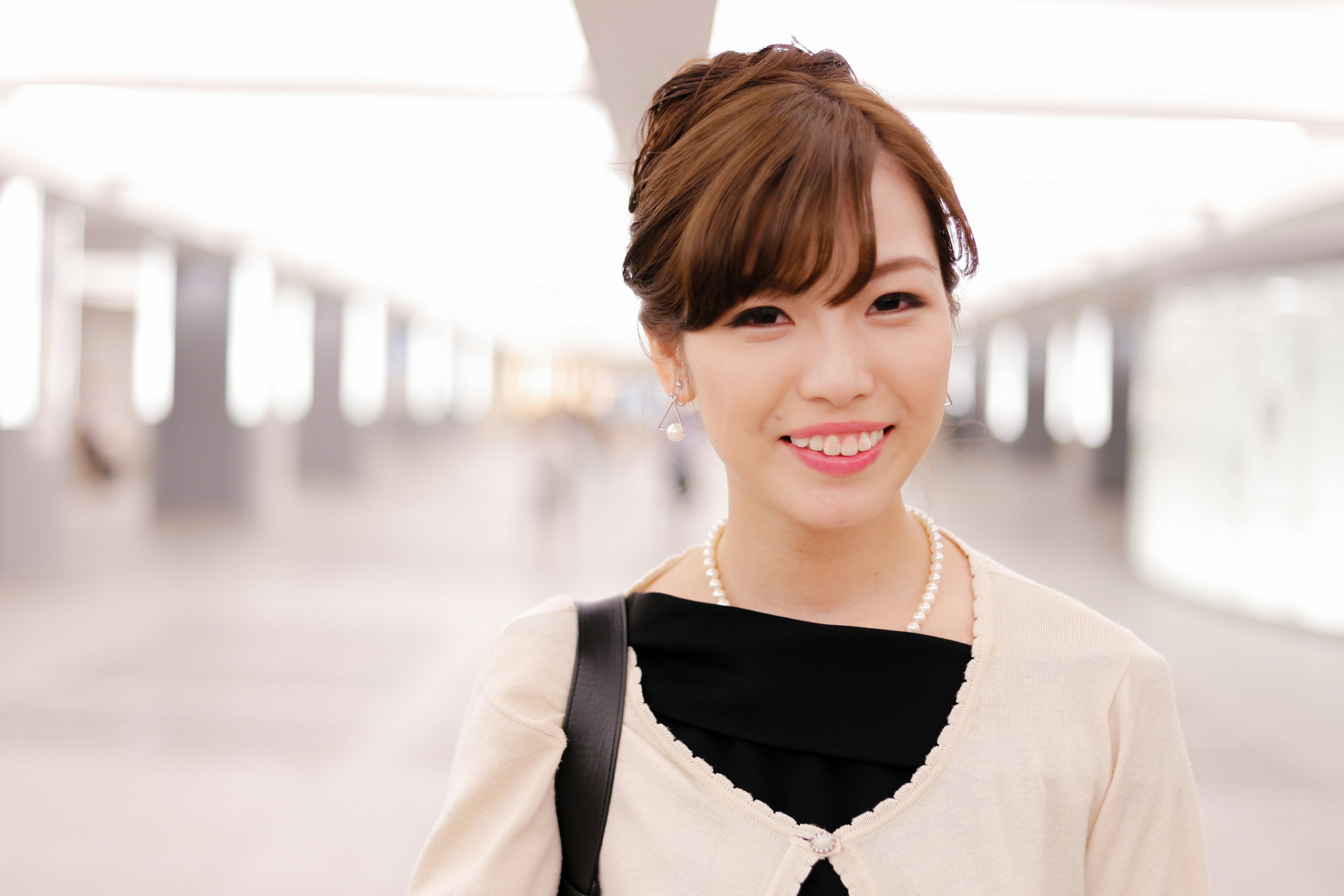smiling woman in a white colonnade corridor