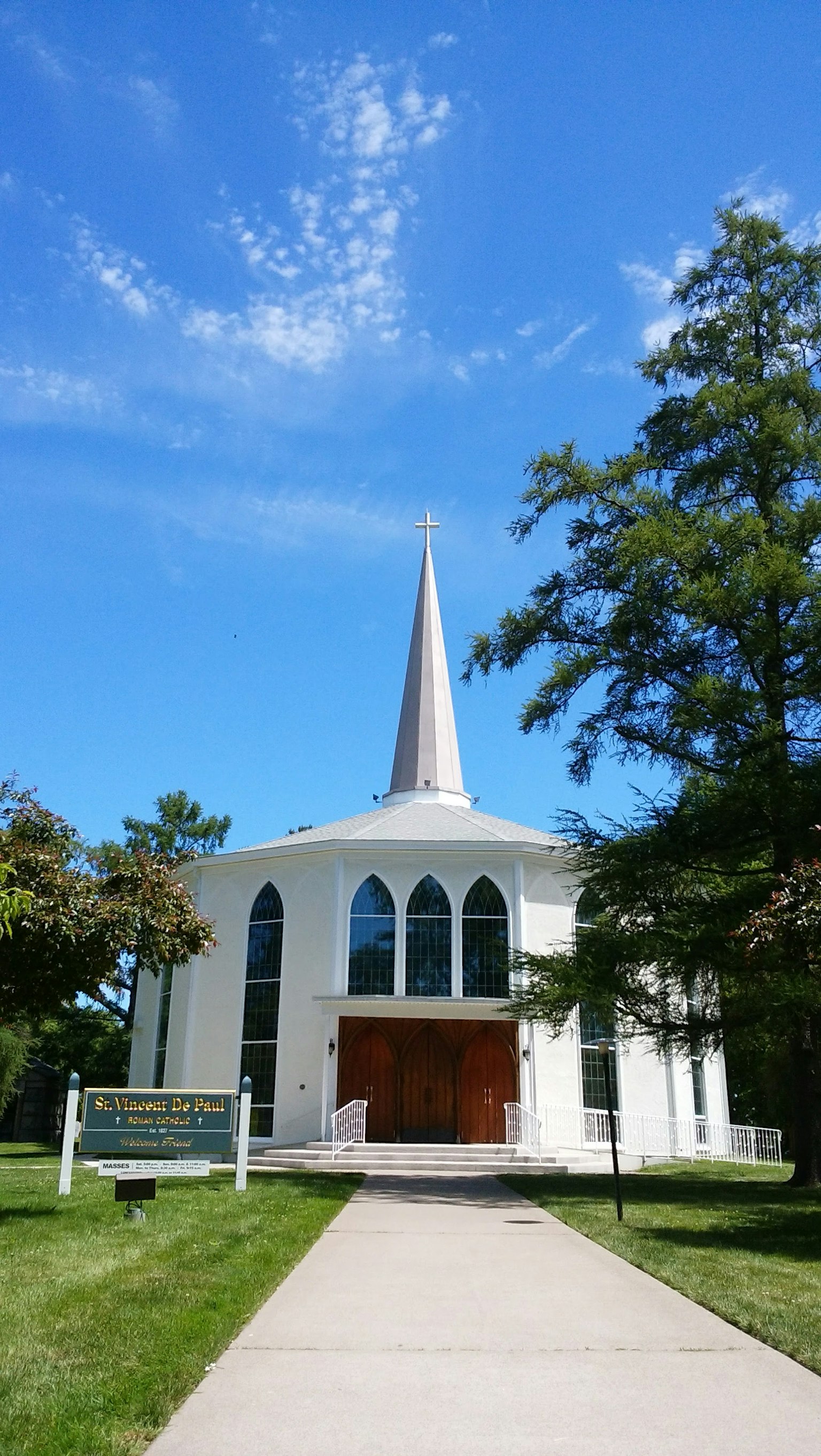 Iglesia blanca con una aguja alta bajo un cielo azul