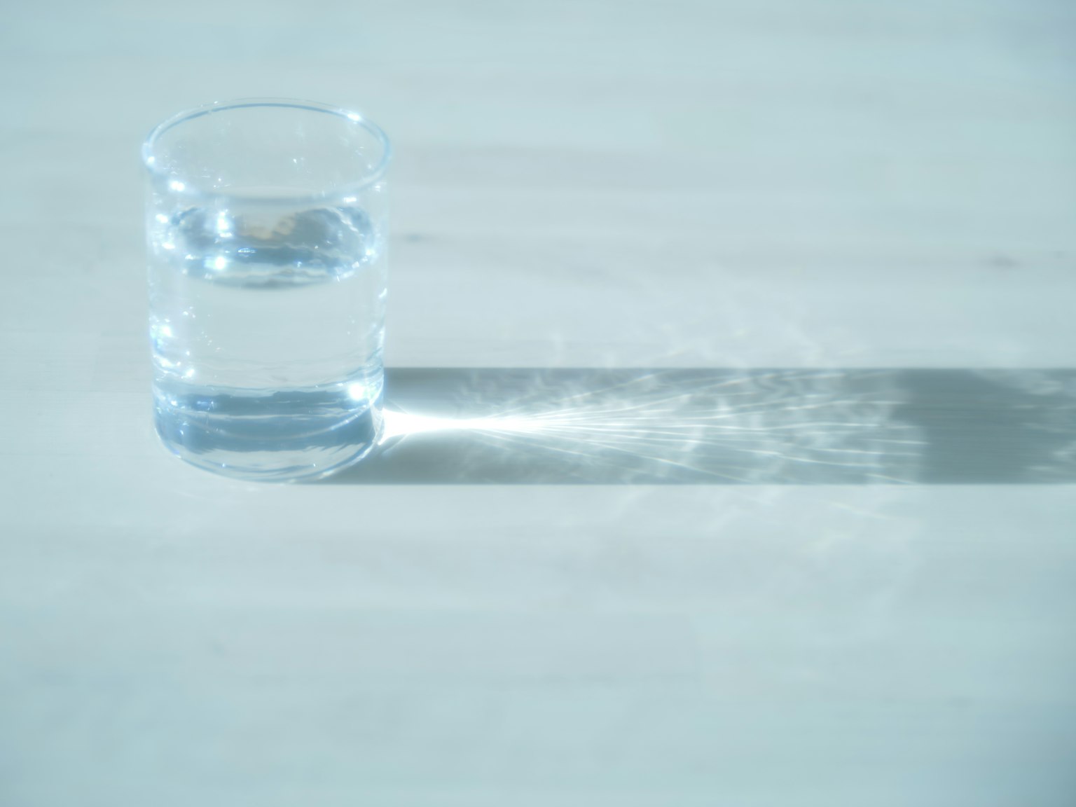 桌子上的透明水杯投射出长长的阴影