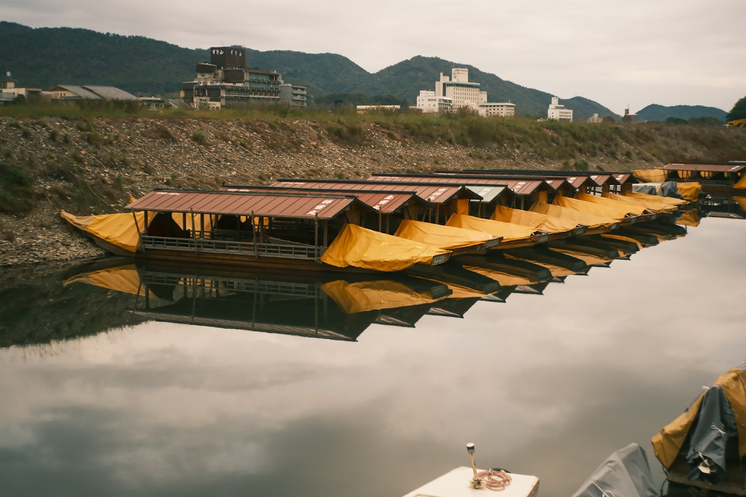 川に並ぶ黄色い屋根の小舟が映る風景
