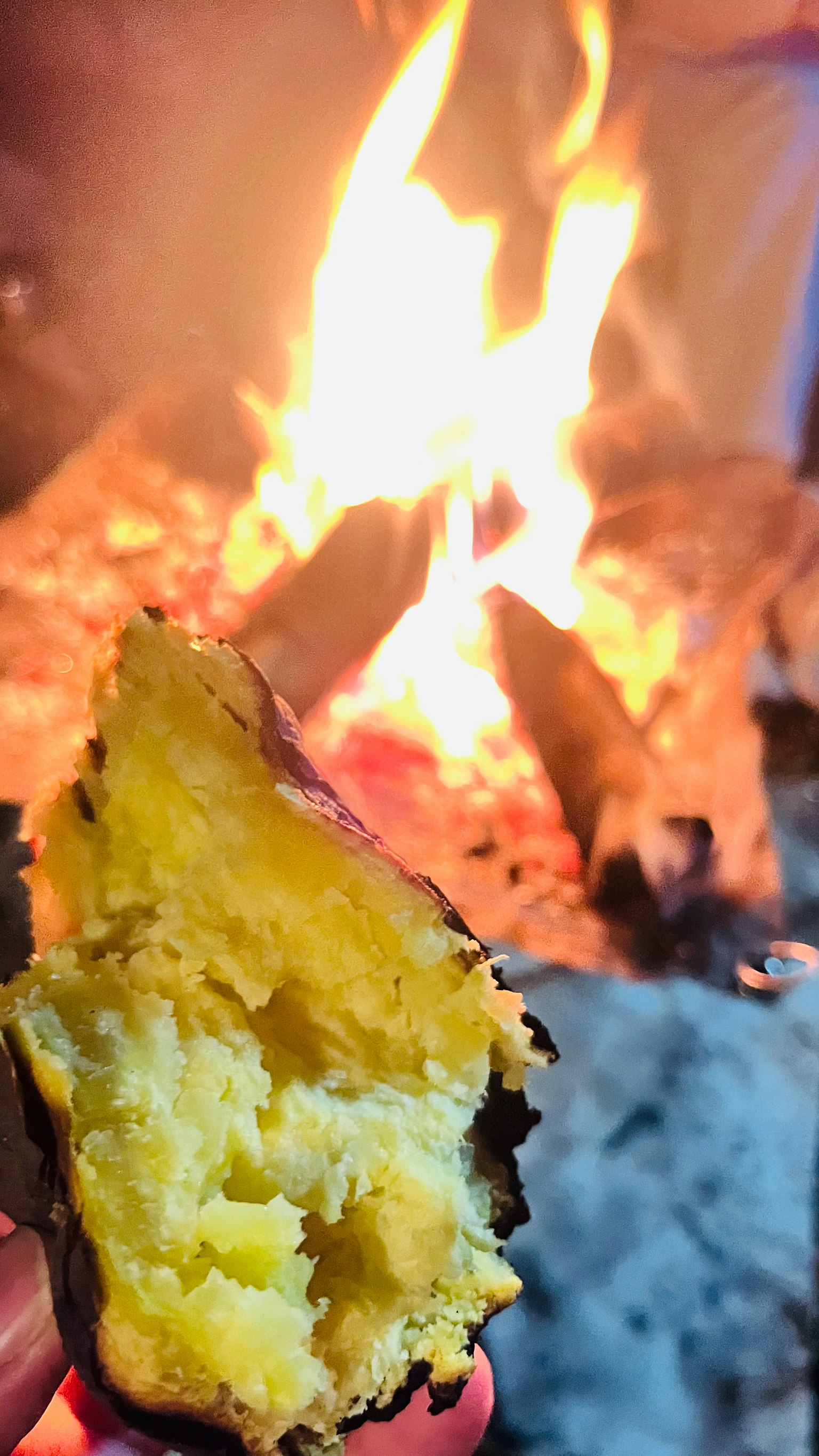 Sezione trasversale di una patata dolce arrostita davanti a un falò
