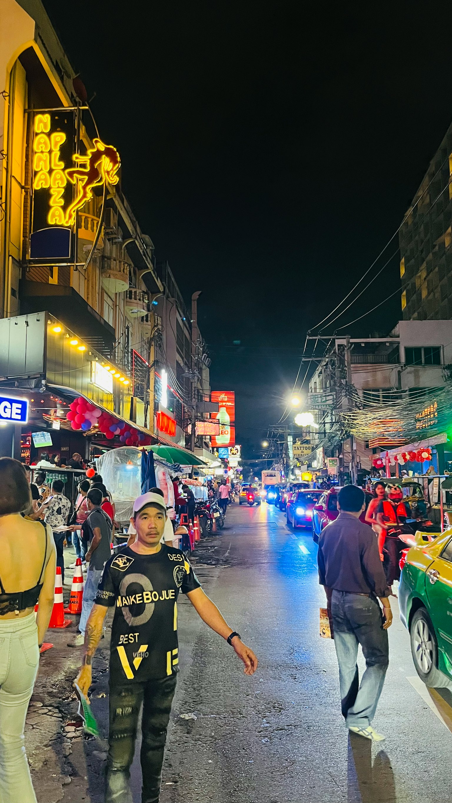 夜间繁忙街道场景，有人和霓虹灯招牌