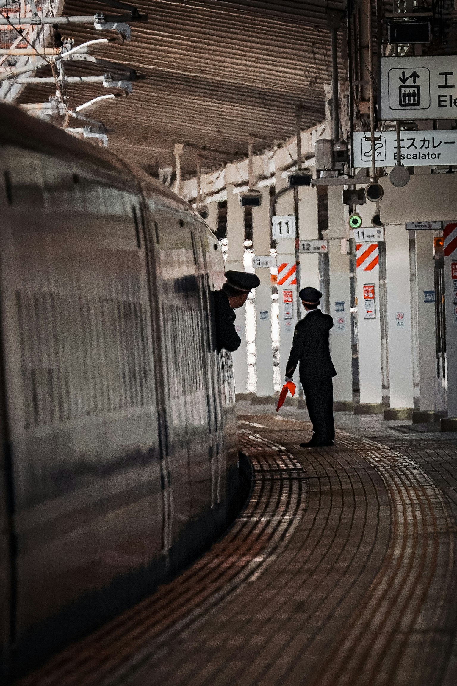 Nền ga tàu với nhân viên giám sát một chiếc tàu và bên của nó