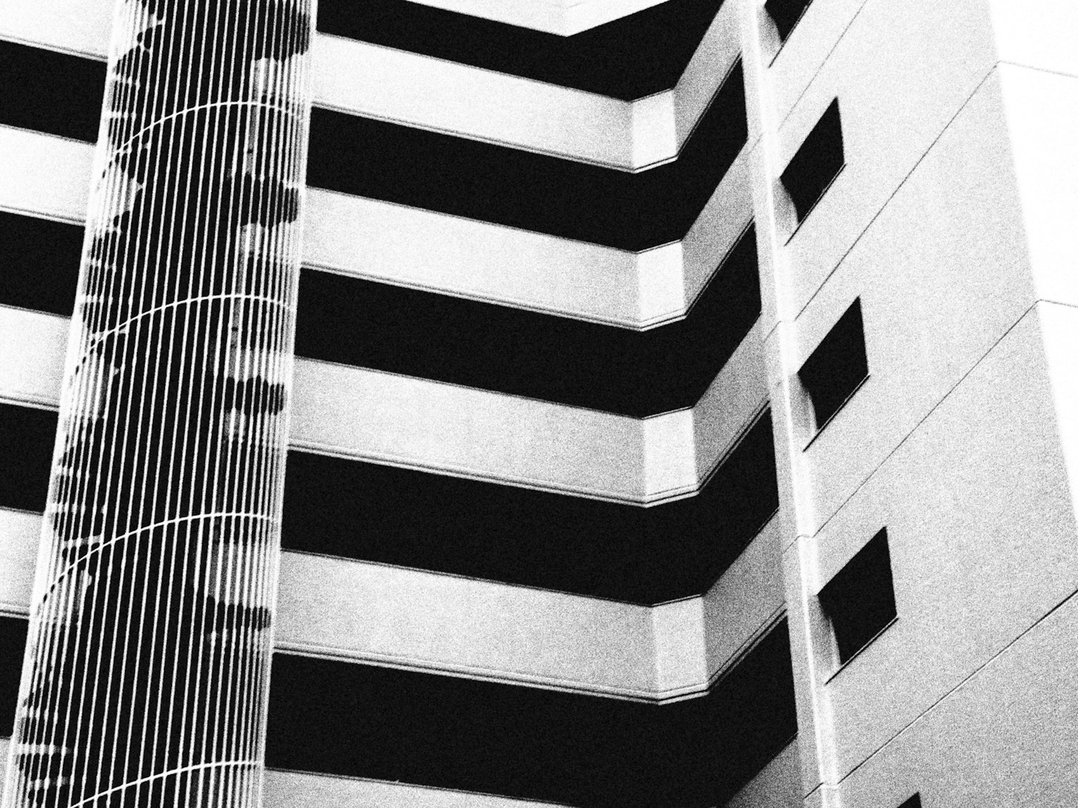 Black and white modern building exterior featuring linear and stepped design