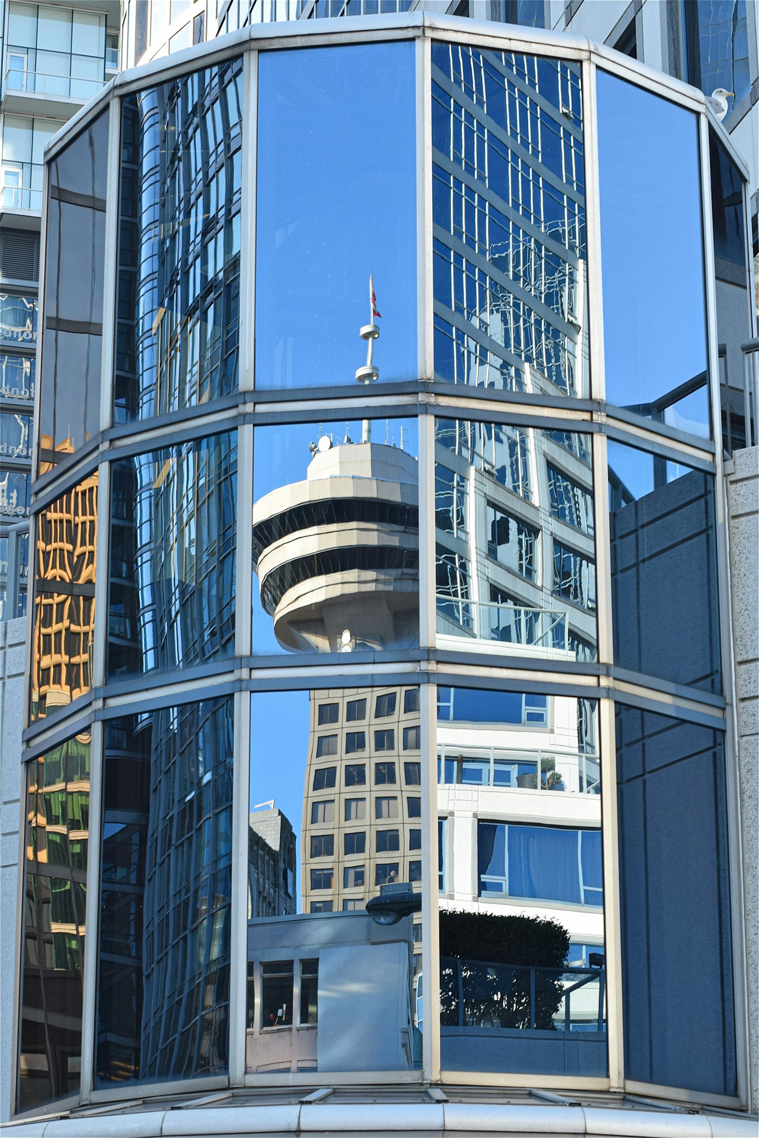 Refleksi Canada Place di jendela gedung tinggi dengan pemandangan kota