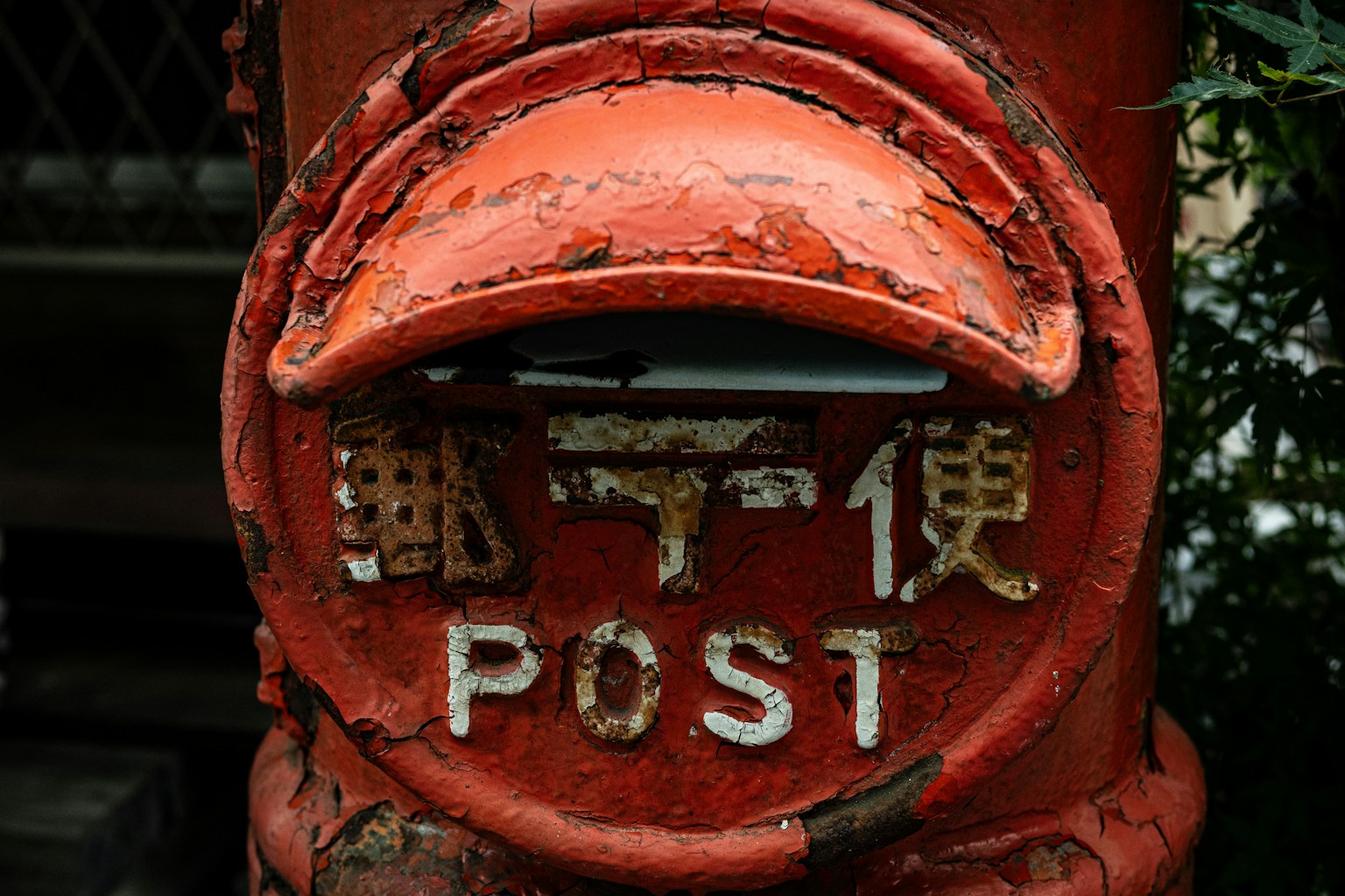 Old red post box with the word 'POST' written on it