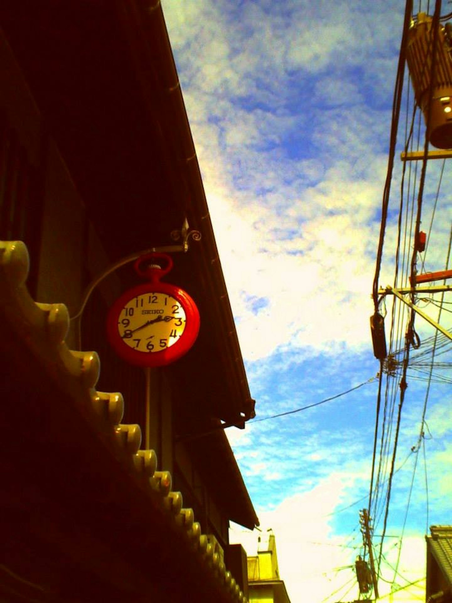 Reloj rojo en un edificio antiguo con cielo azul