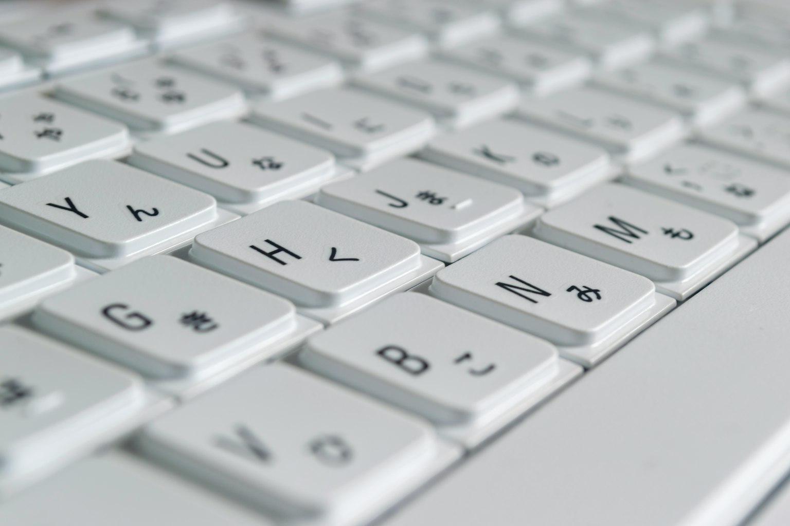 Close-up of a white keyboard showing Japanese characters