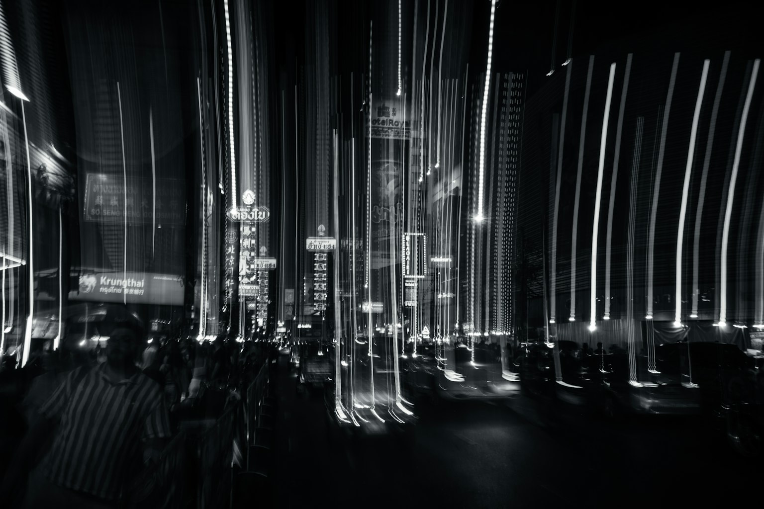Paysage nocturne urbain en noir et blanc avec des traînées de lumière allongées