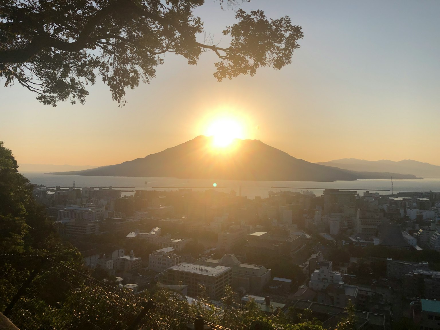 Hermoso atardecer detrás de una montaña con vista a una ciudad