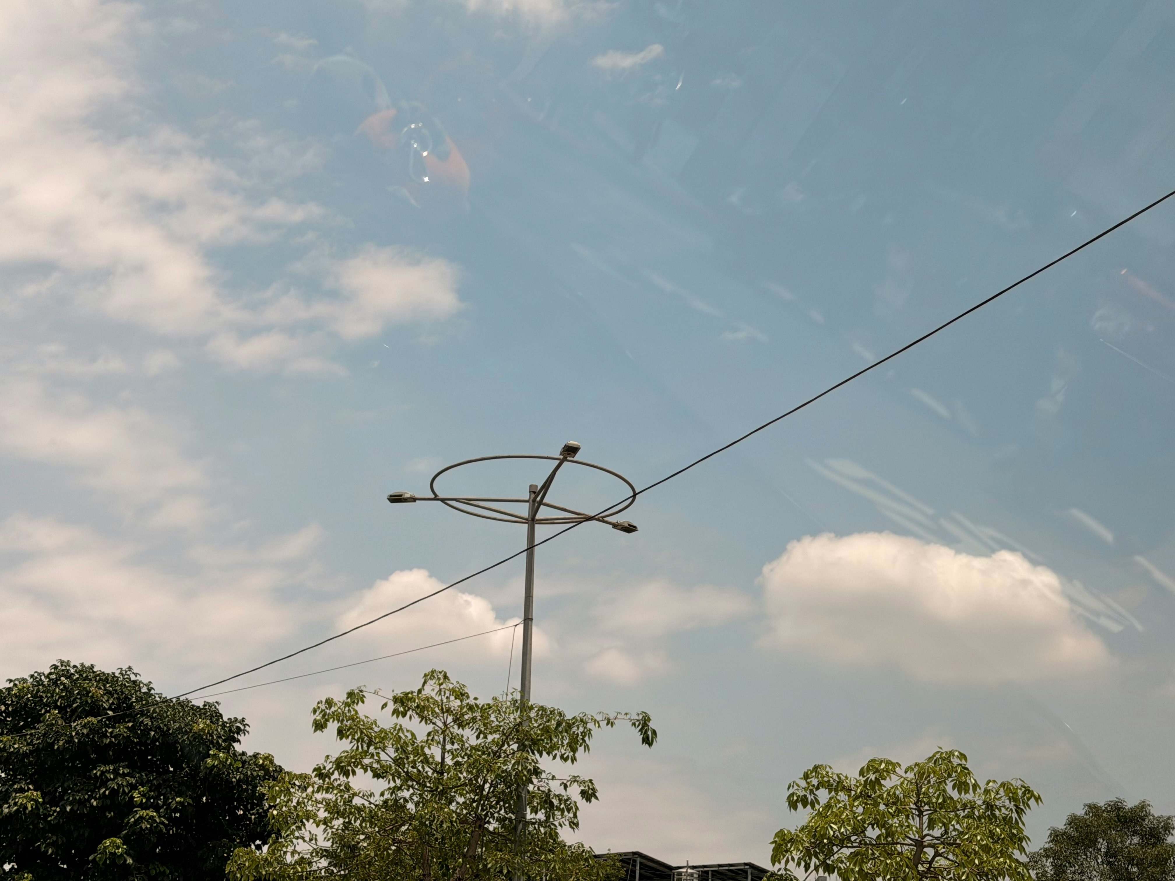 空に伸びる電線と街灯のある空模様
